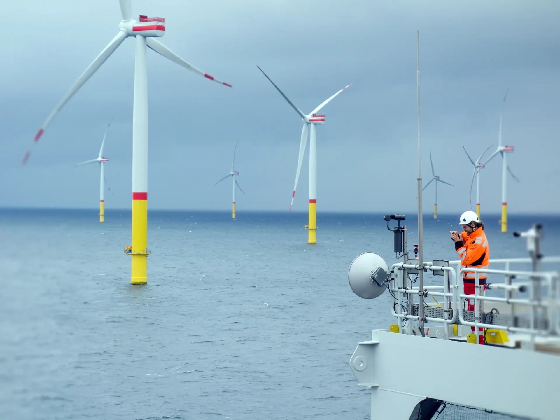 Operator on a ship next to a few wind turbines