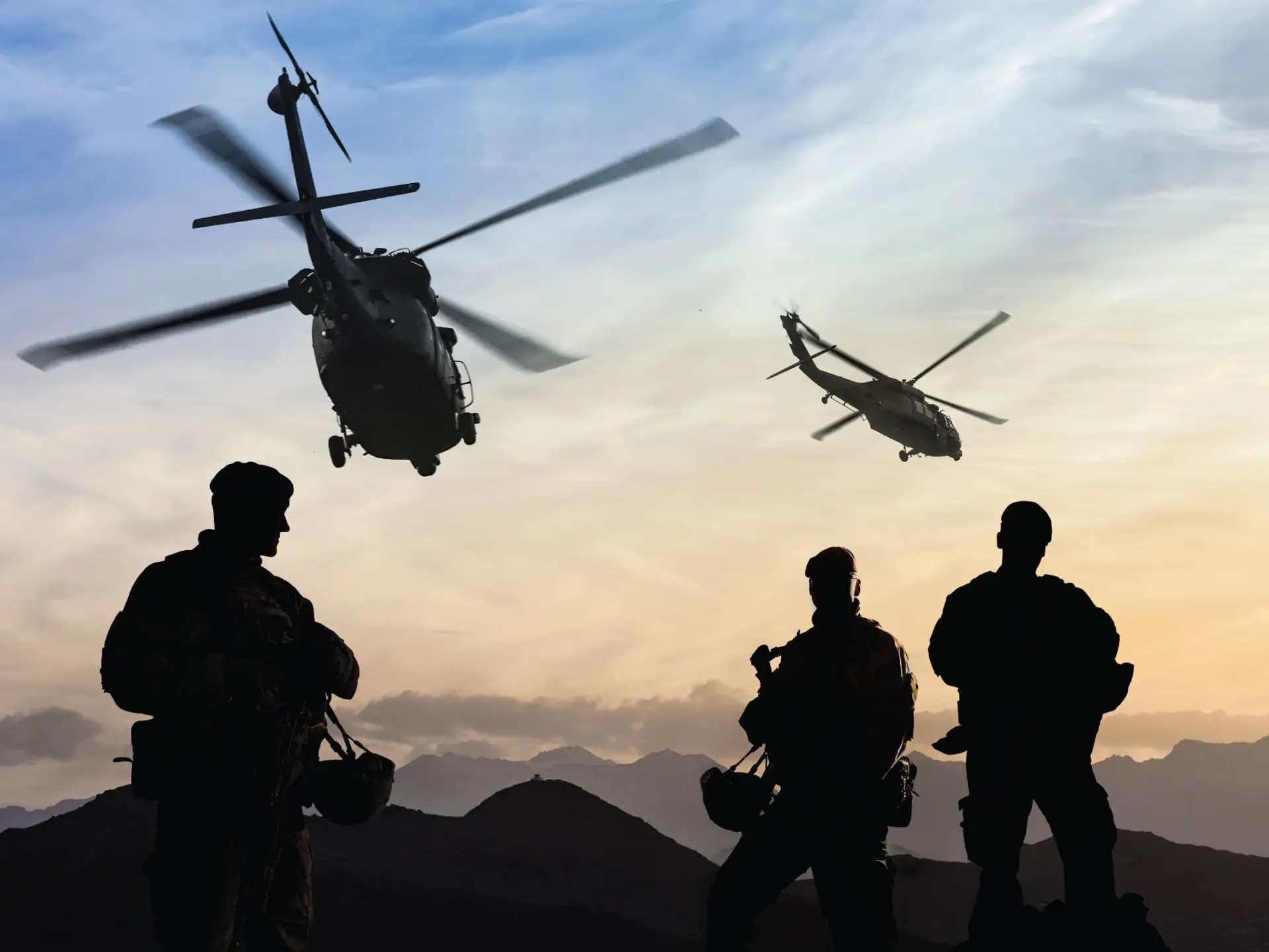 Helicopters flying above soldiers in shadow