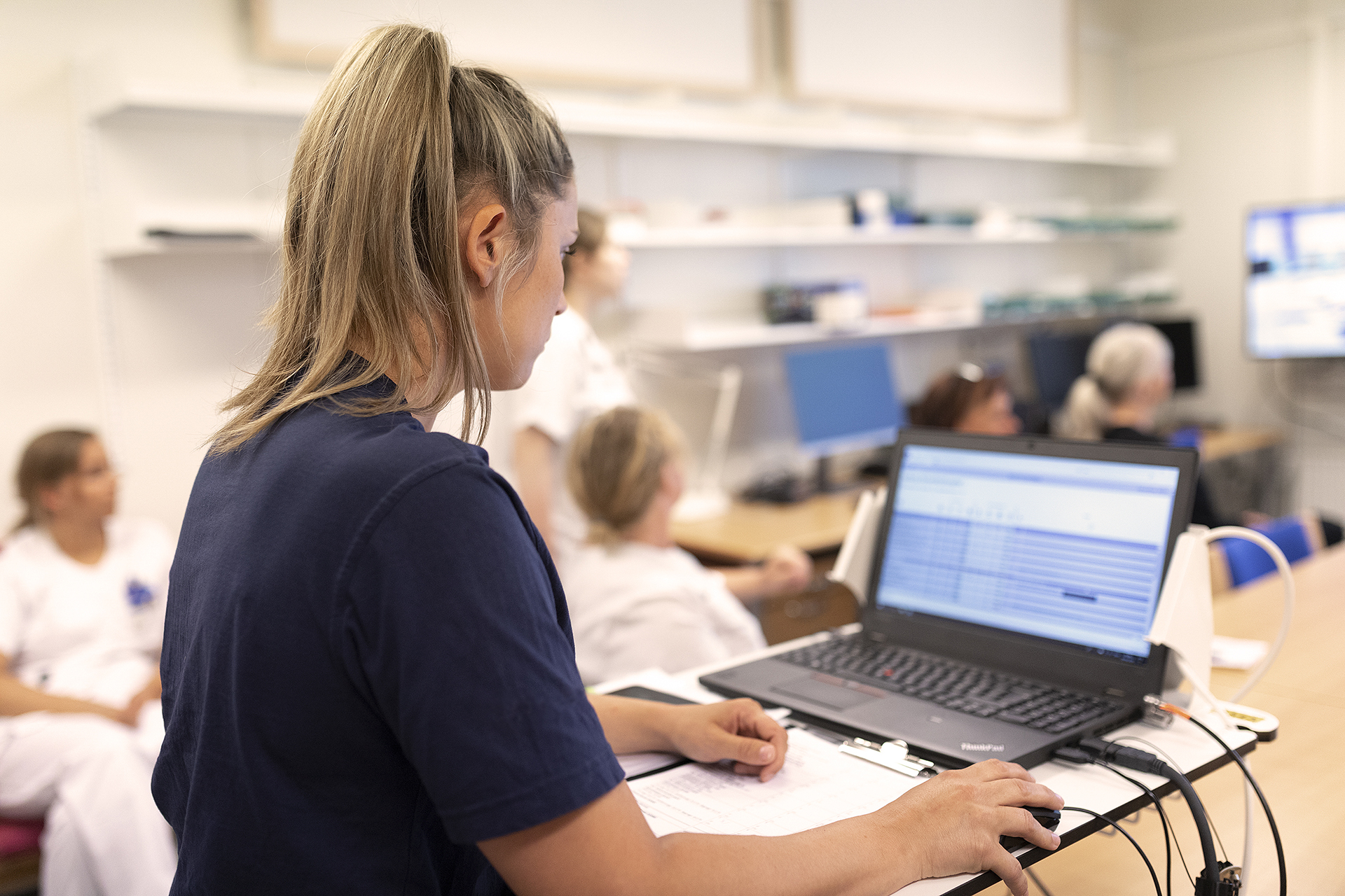 Nurse looking at computer with EMR data in Columna CIS