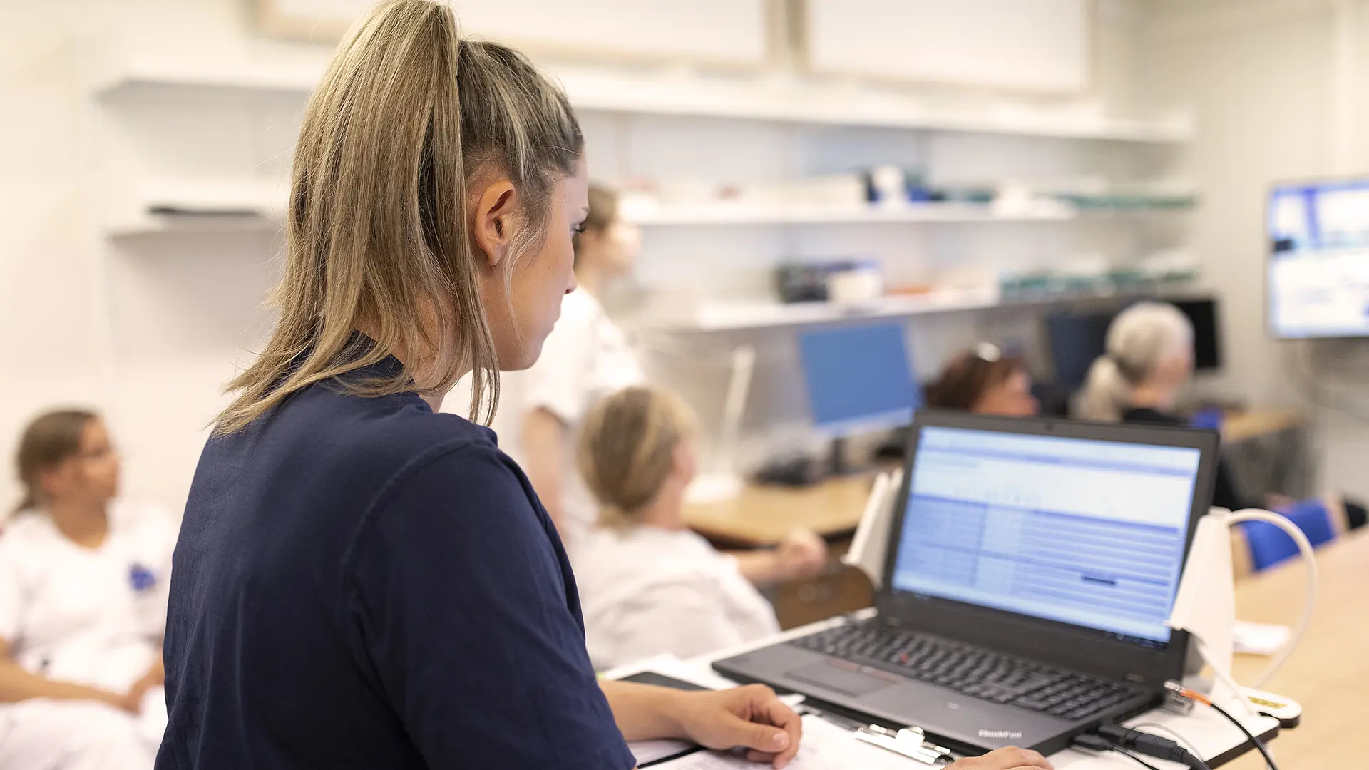 Nurse looking at computer with EMR data in Columna CIS