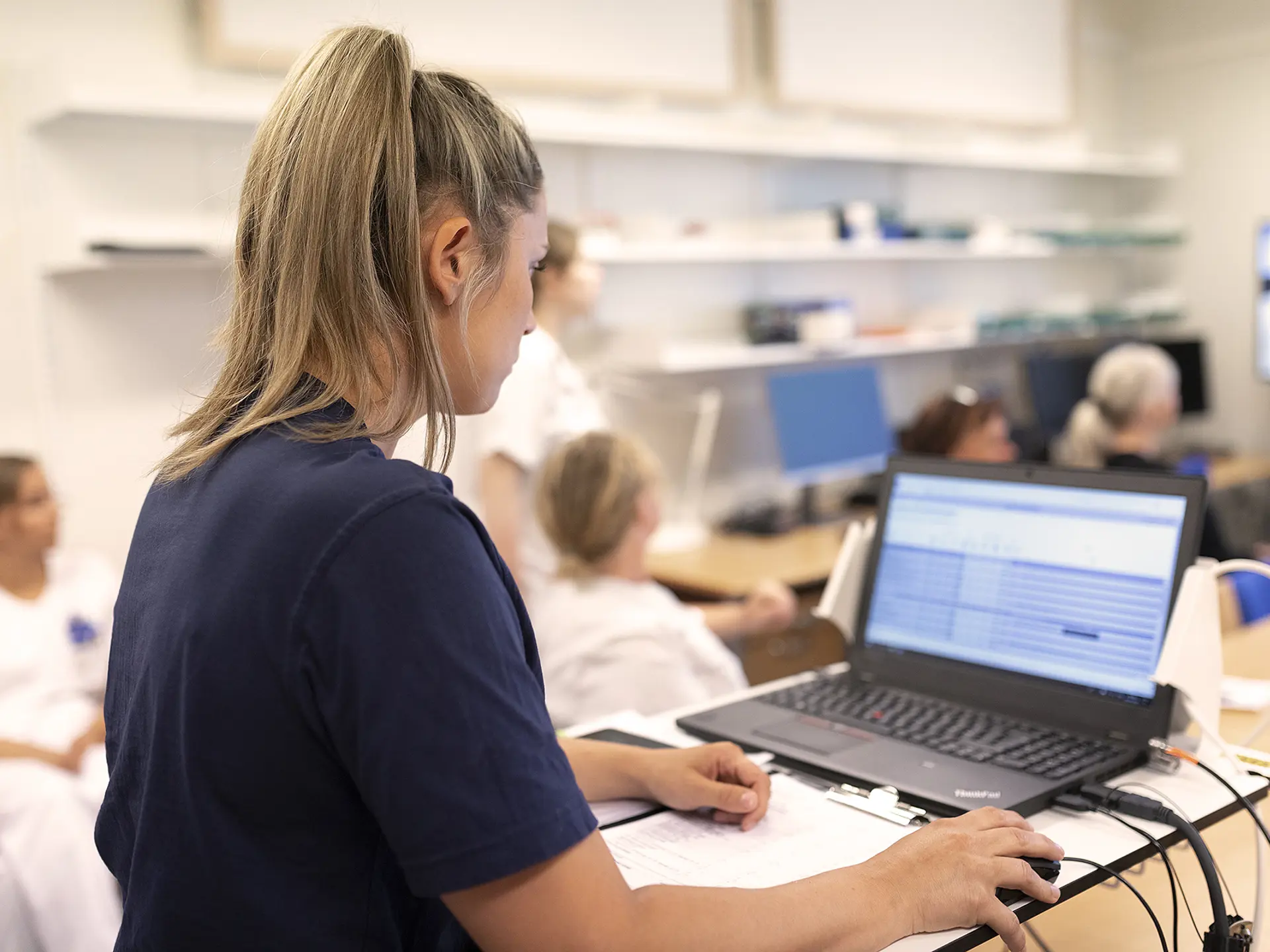 Nurse looking at computer with EMR data in Columna CIS