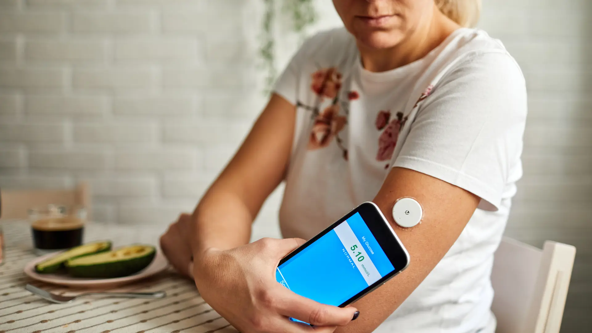 Woman Swiping Sensor With Smart Phone For Glucose Mesaurement