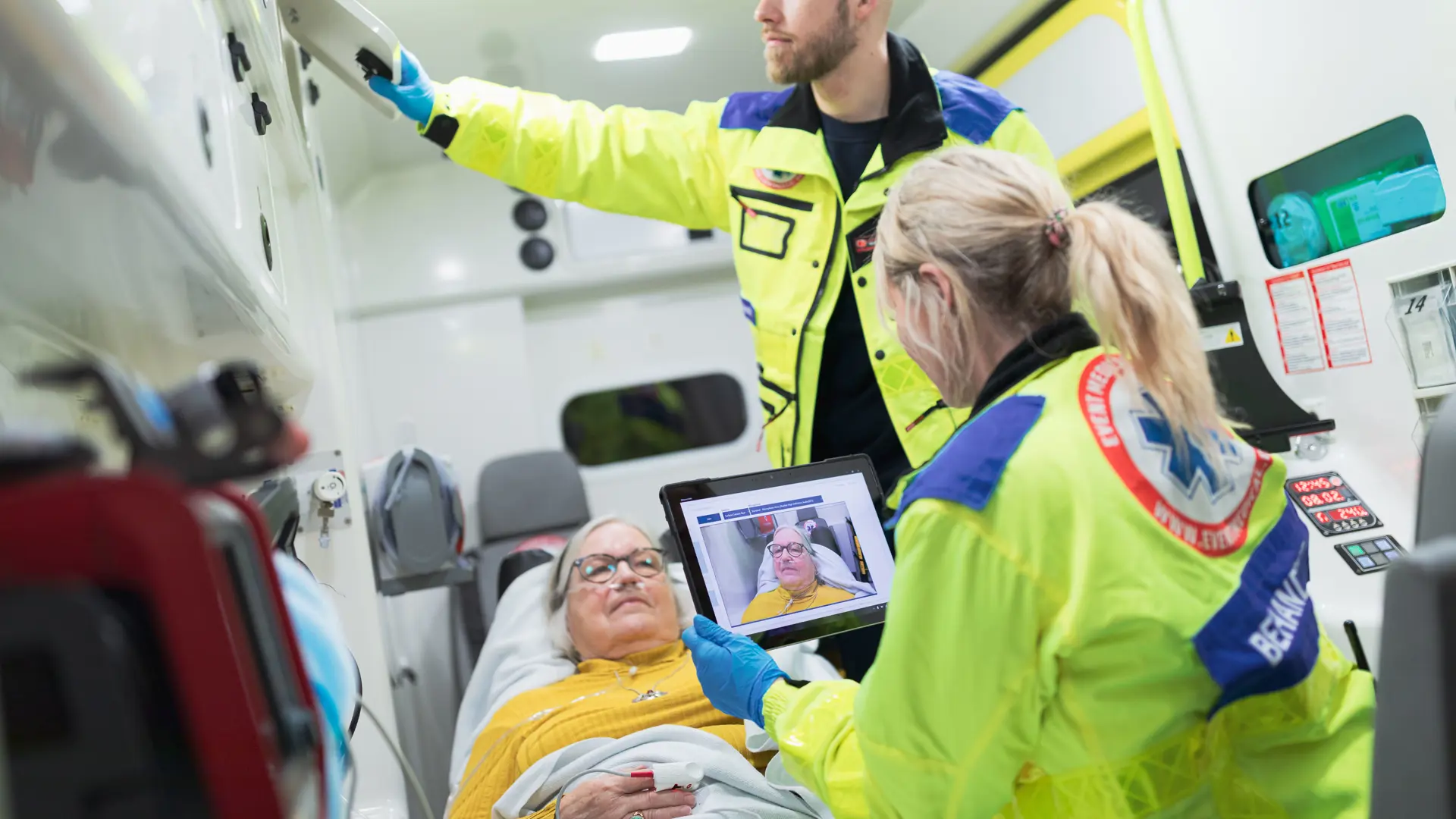 Paramedicinere behandler en patient, mens de videochatter med akutmodtagelsen