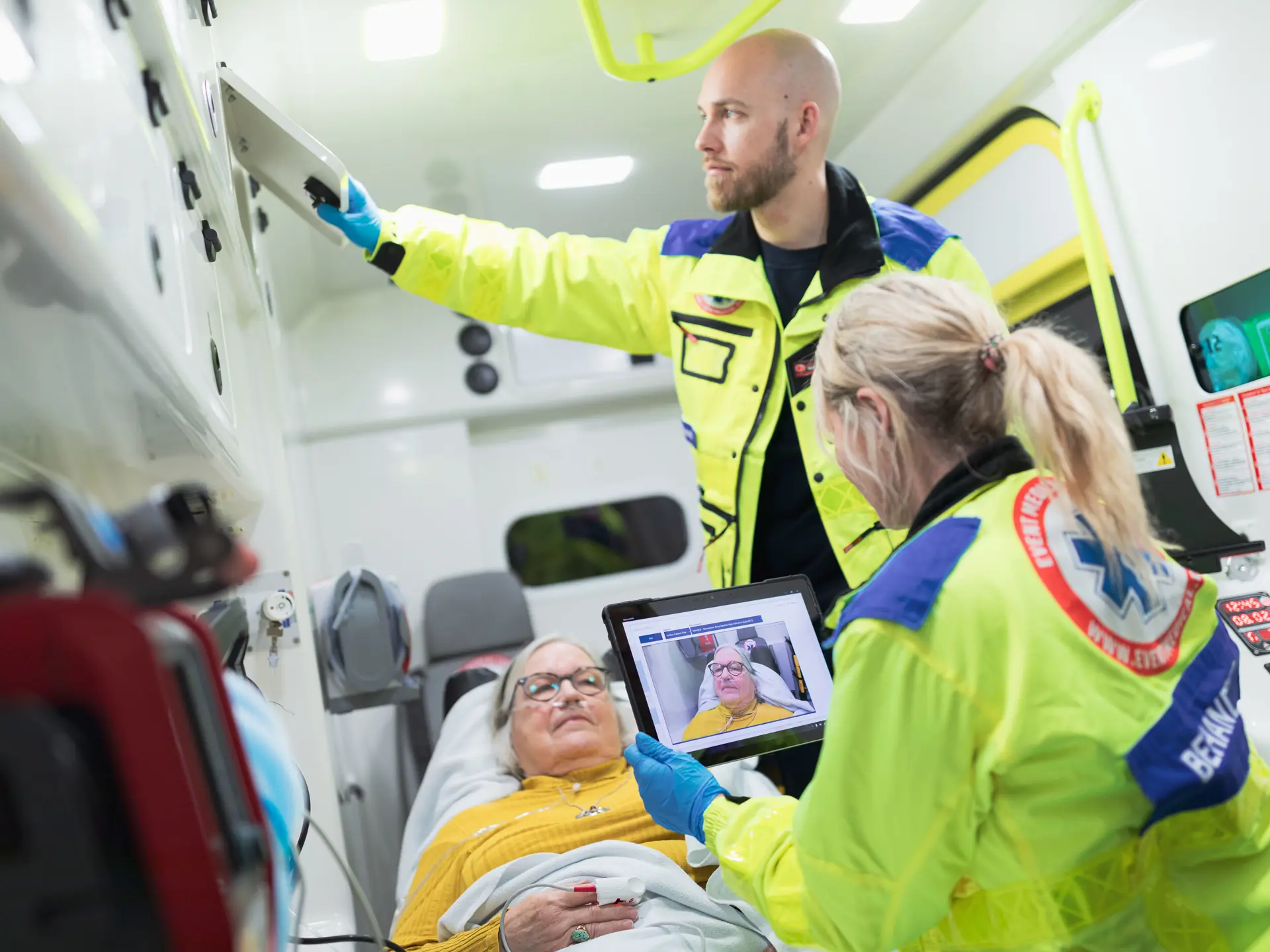 Paramedicinere behandler en patient, mens de videochatter med akutmodtagelsen