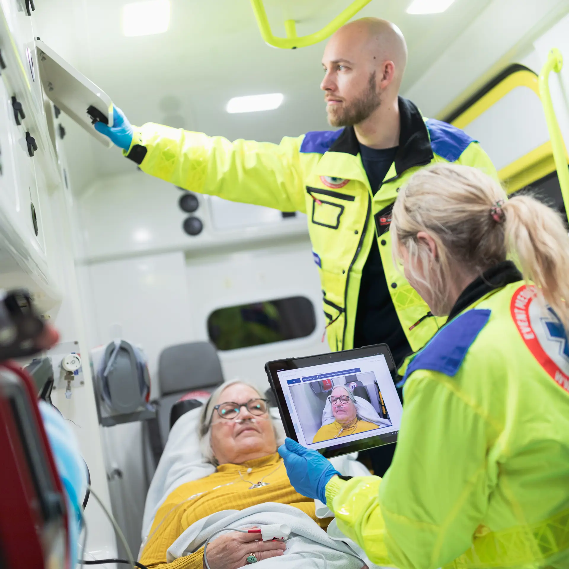 Paramedicinere behandler en patient, mens de videochatter med akutmodtagelsen