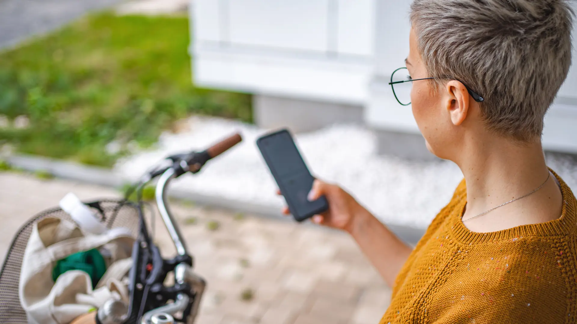 Social- og sundhedsassistent med mobiltelefon og cykel