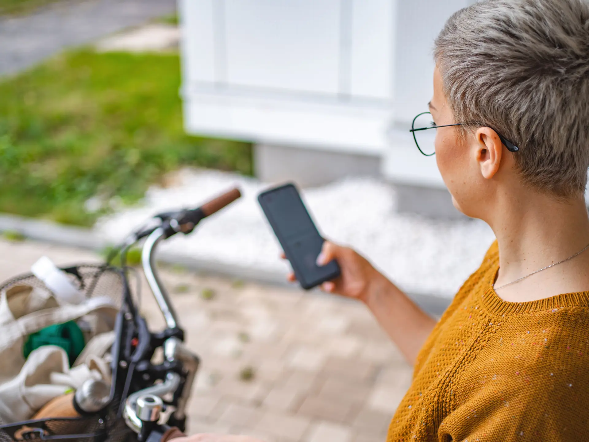 Social- og sundhedsassistent med mobiltelefon og cykel