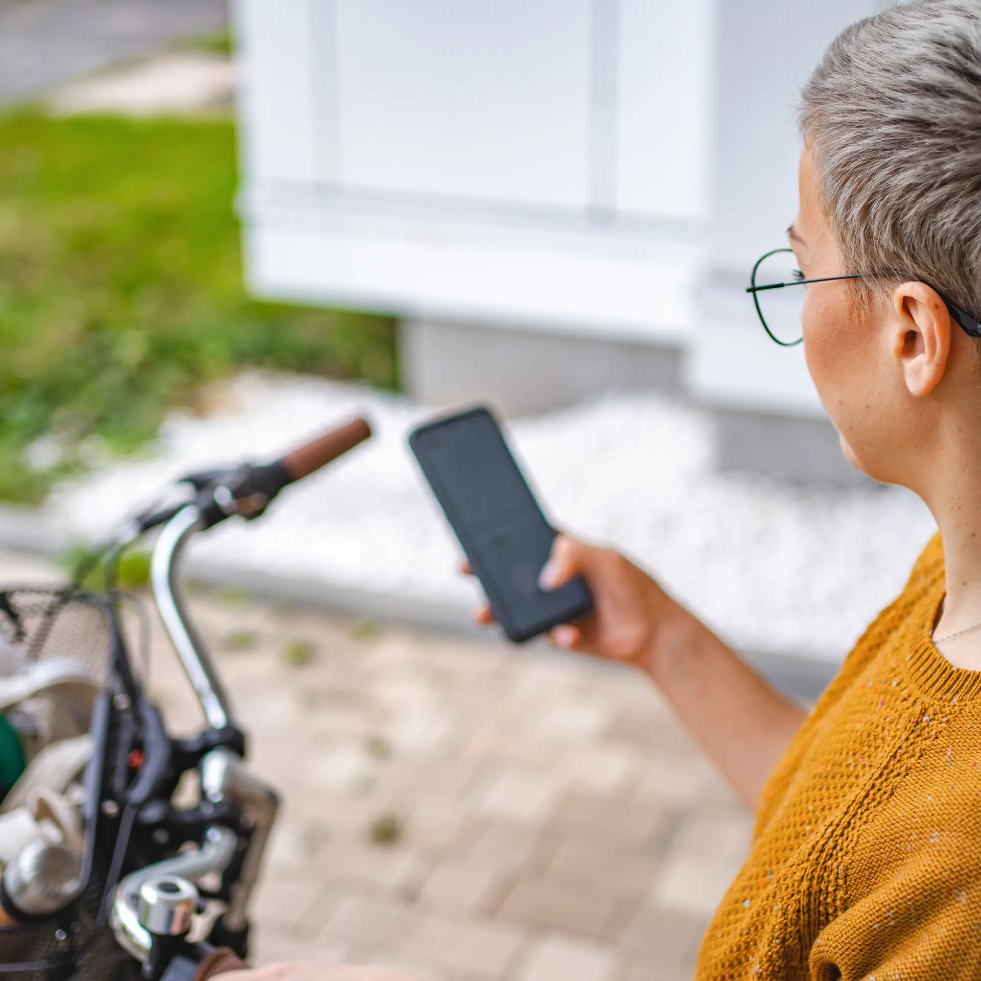 Social- og sundhedsassistent med mobiltelefon og cykel