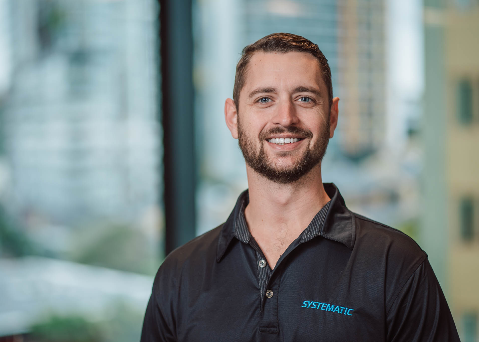 Employee wearing a Systematic logo t-shirt smiling