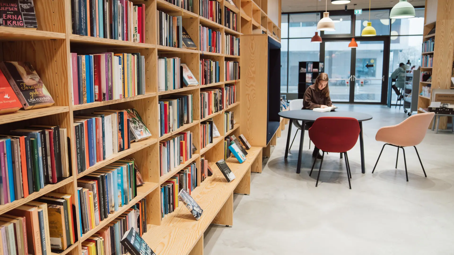 Girl sitting among book shelves in a library that uses Cicero