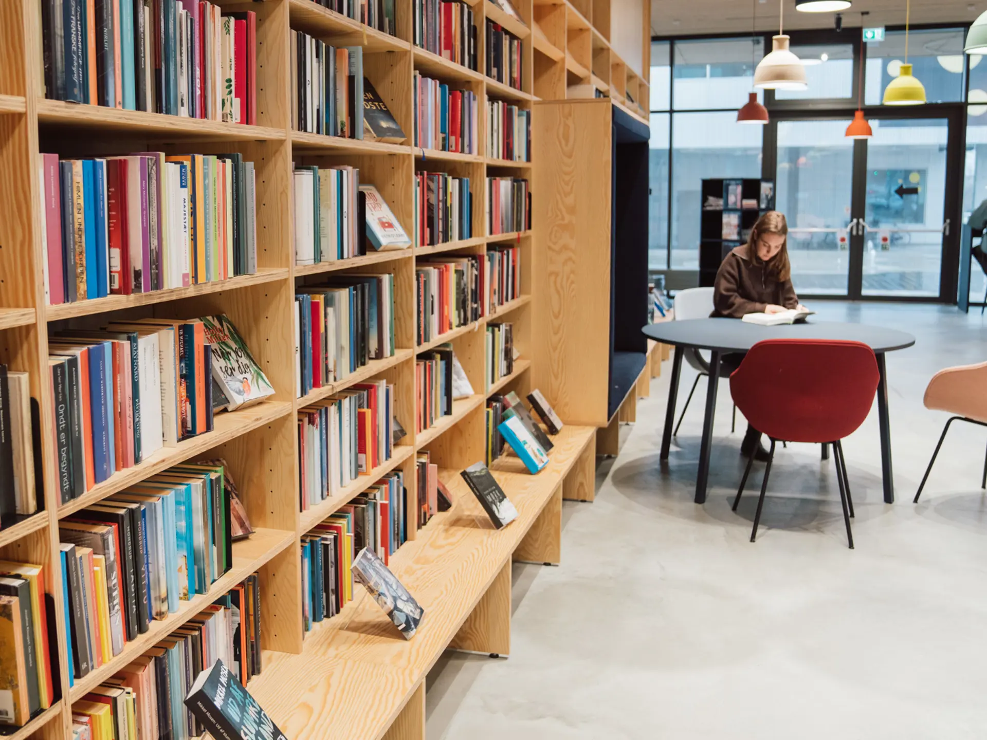 Girl sitting among book shelves in a library that uses Cicero