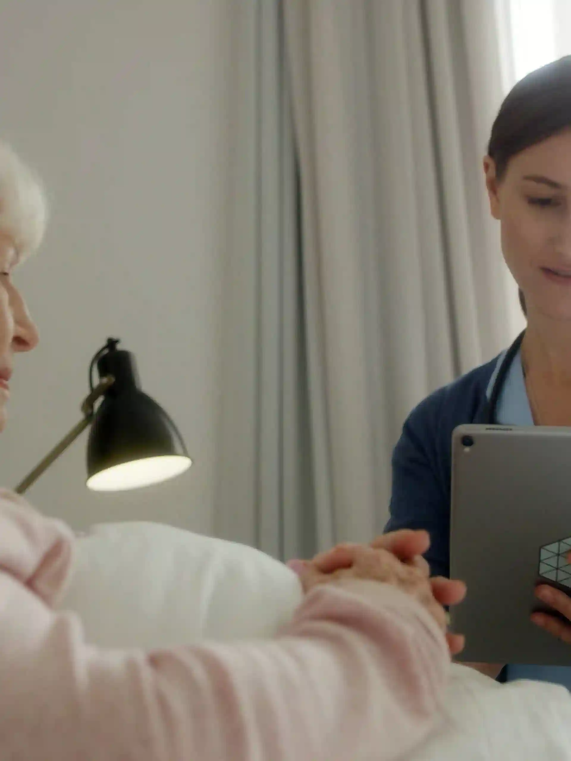 Caregiver-with-tablet-at-citizen-bedside