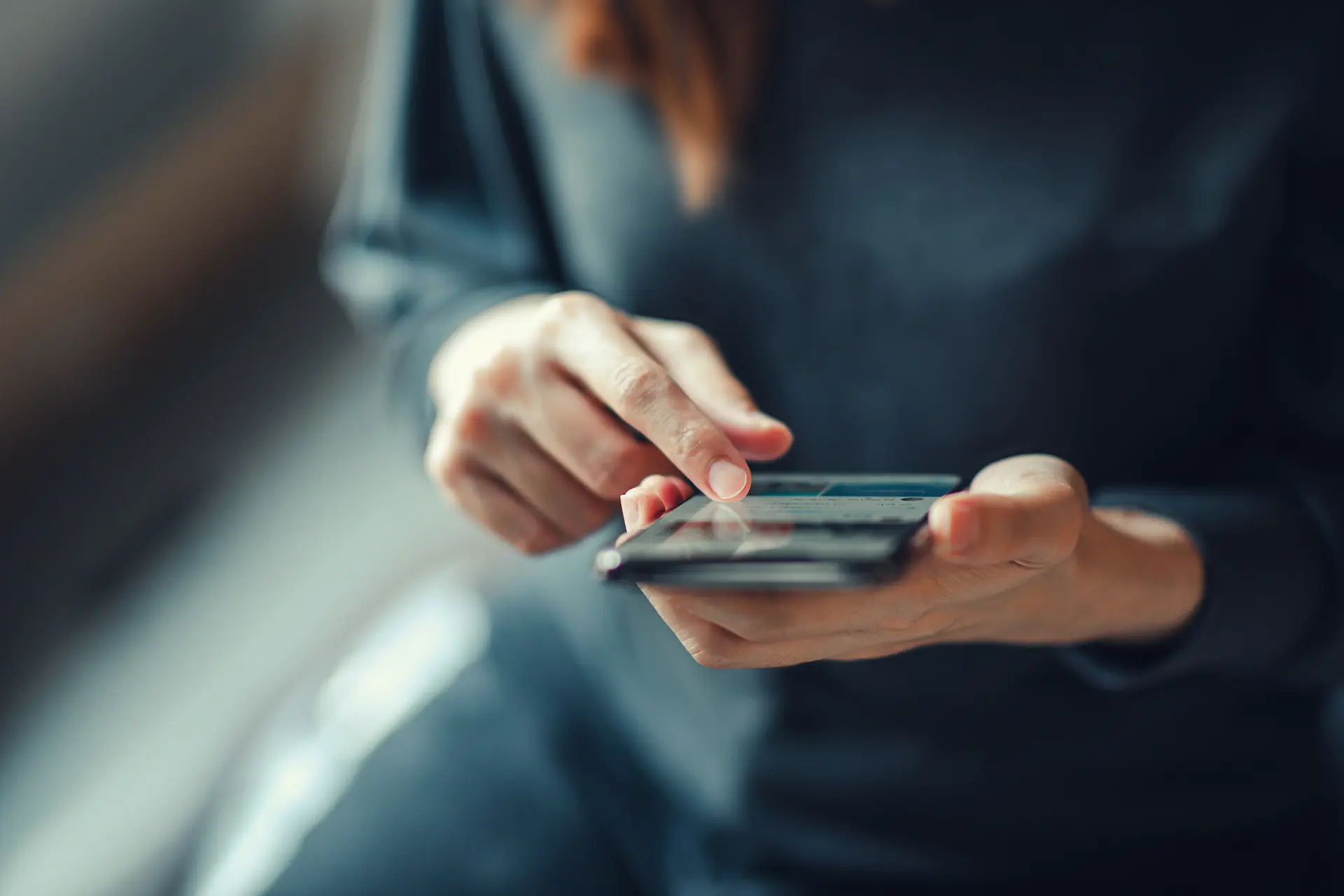 Close-up of a person's hands using a smartphone.