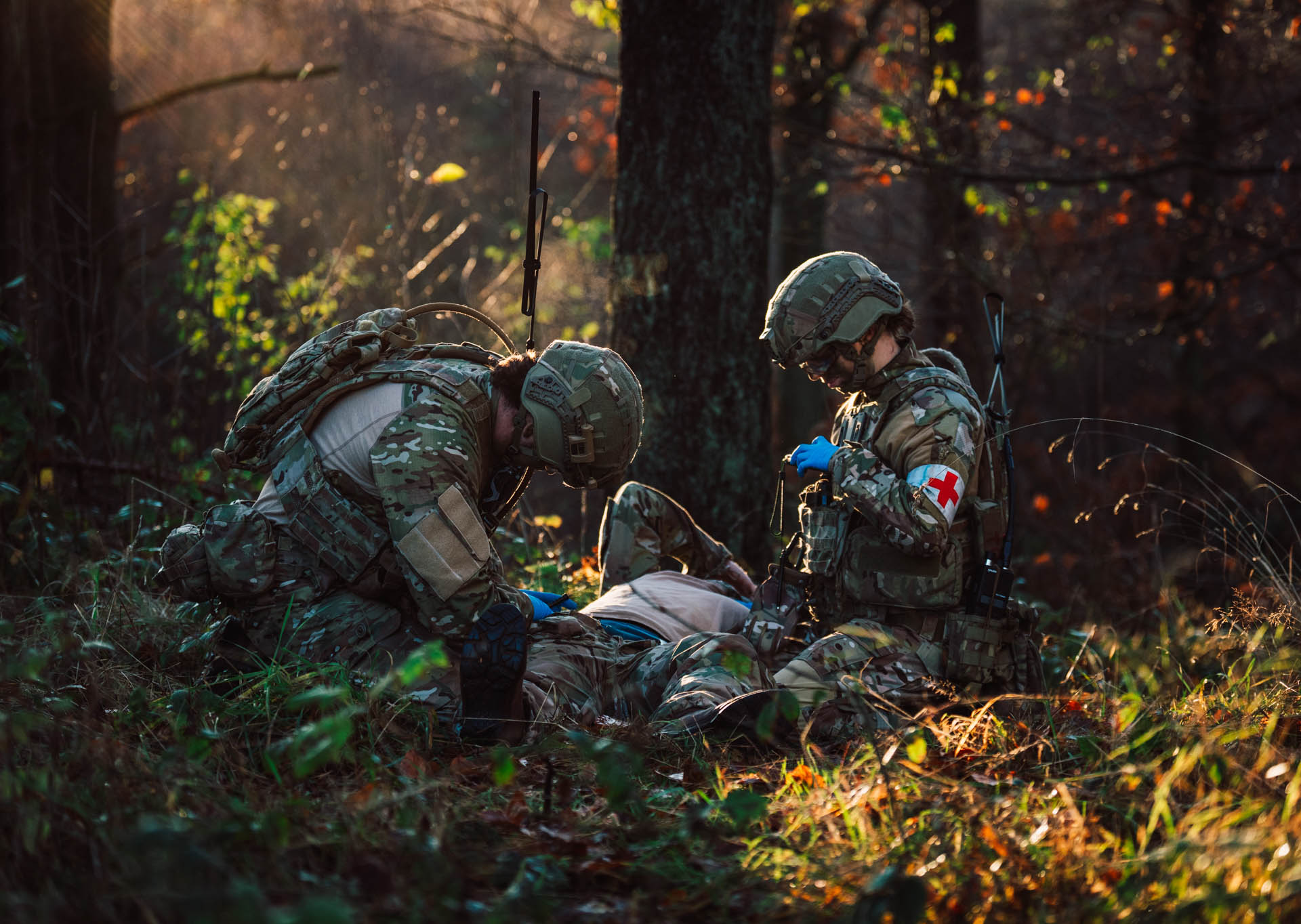 Medics working on soldier in forrest