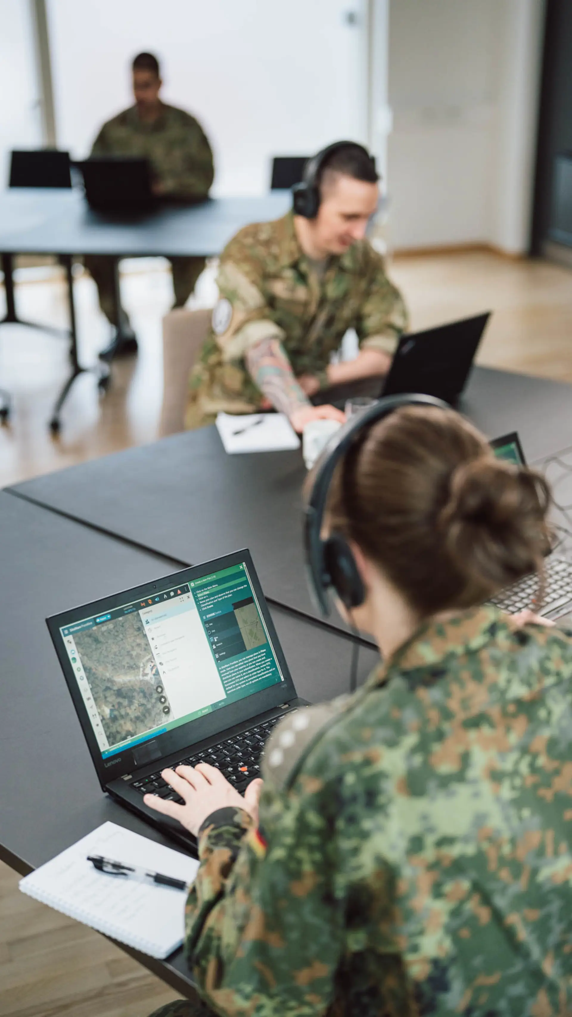 Soldiers being trained in an office setting with SitaWare Aspire software.