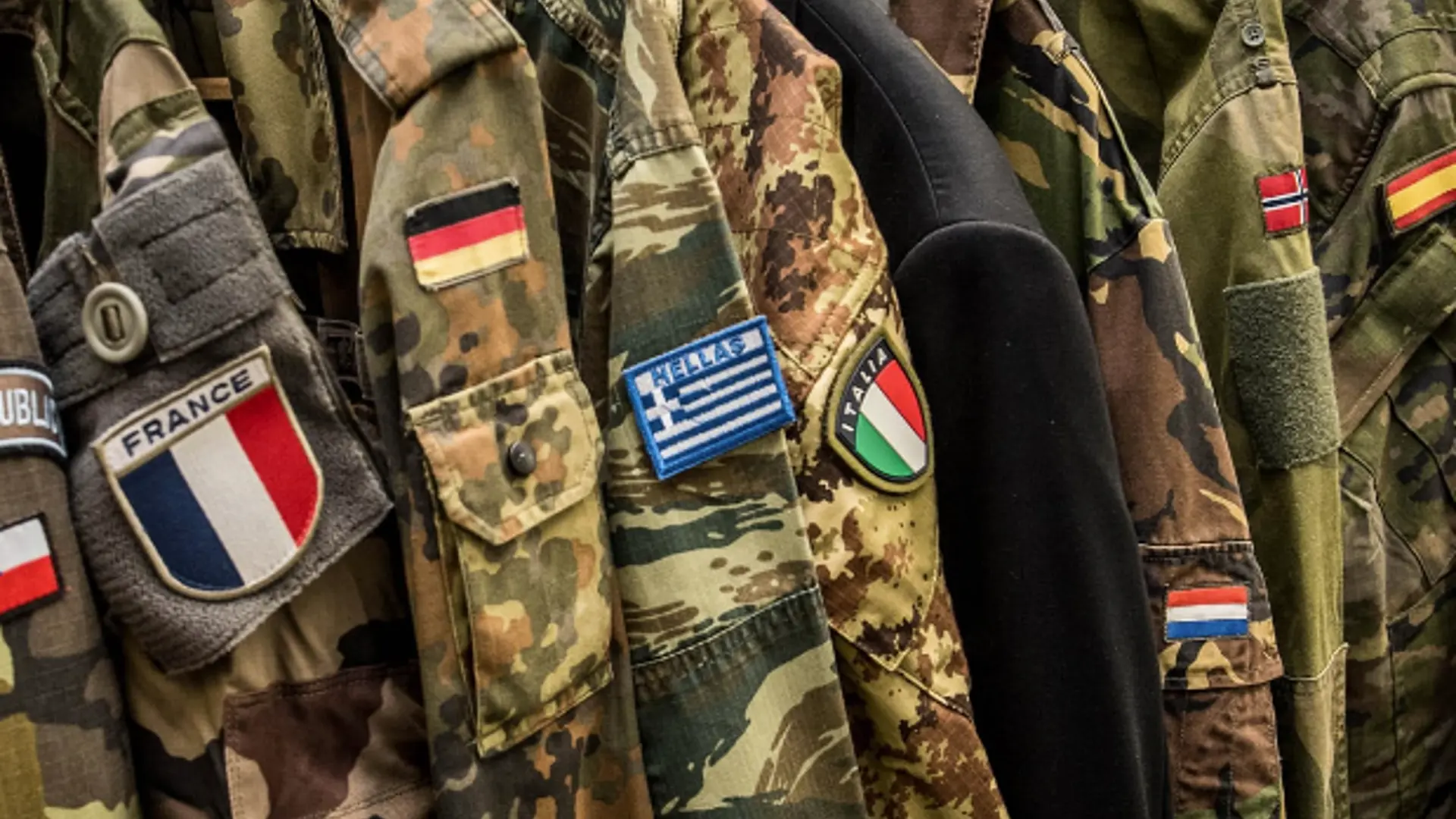 Military uniforms with various nationals flags represented.