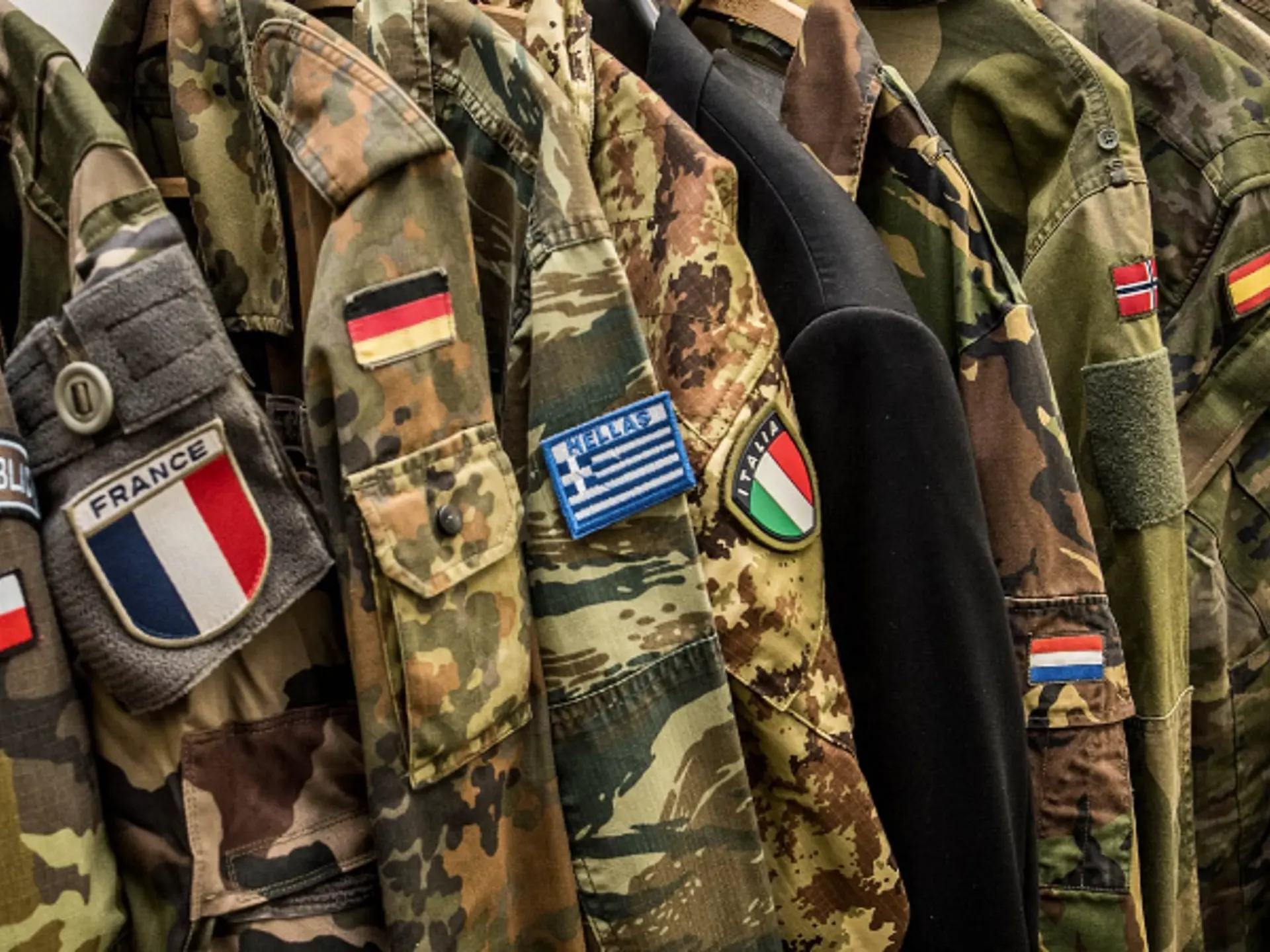 Military uniforms with various nationals flags represented.