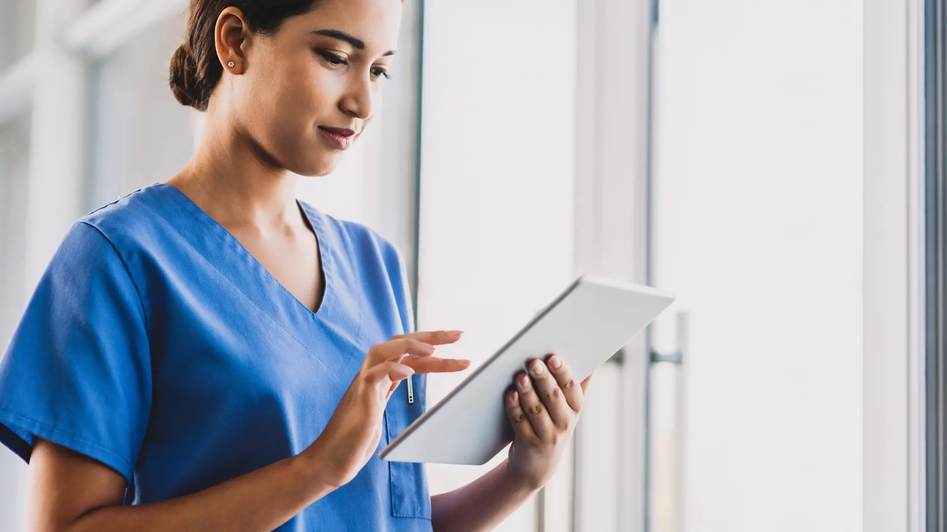 Ung sygeplejerske bruger en tablet