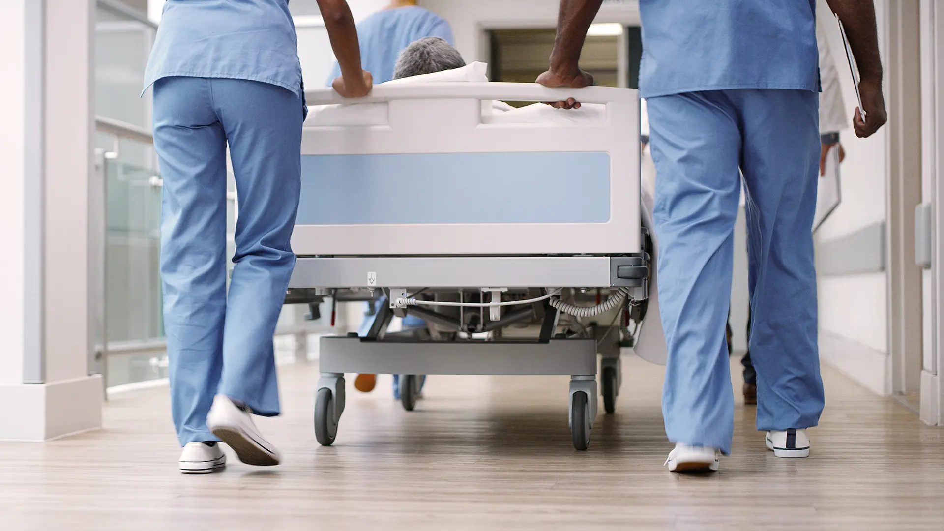 Patient being transported in a hospital bed by doctors