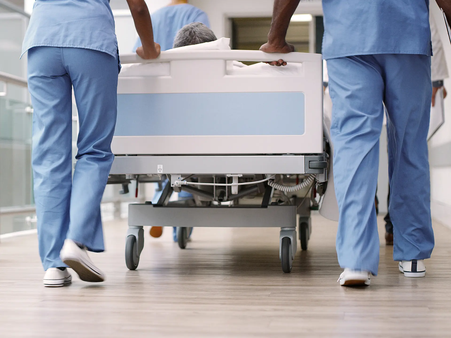 Patient bliver transporteret i en hospitalsseng af læger