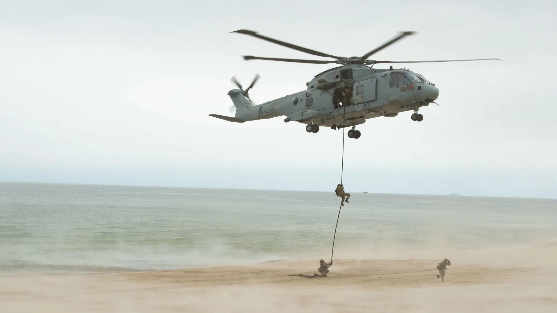 Soldiers rappelling from a helicopter