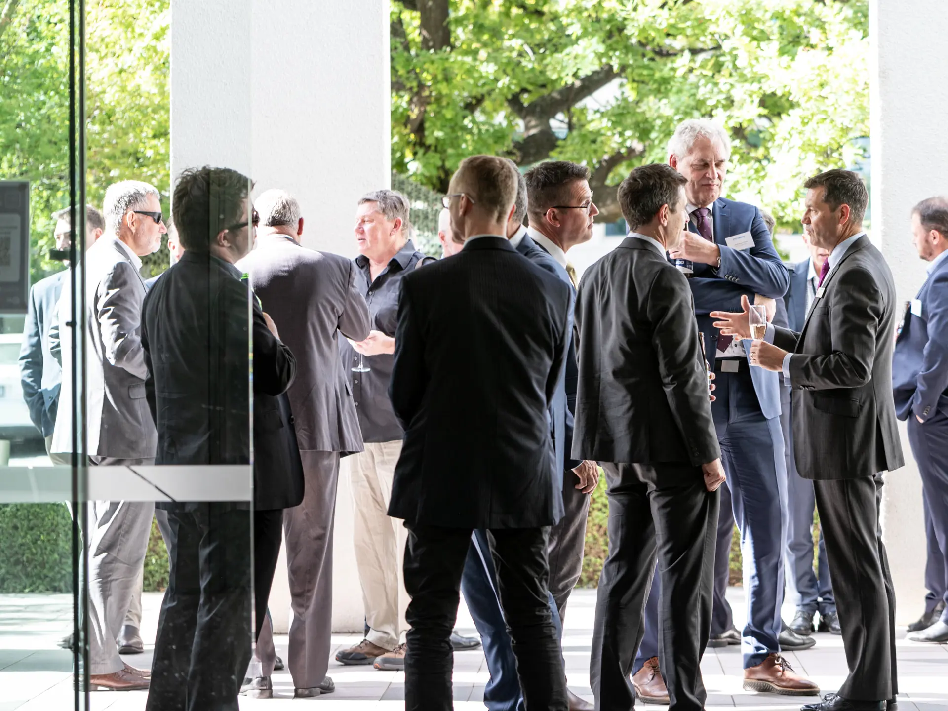 Guests network and converse outside Systematic’s newly opened Asia Pacific headquarters in Canberra, Australia, including employees, partners, and customers in professional attire.