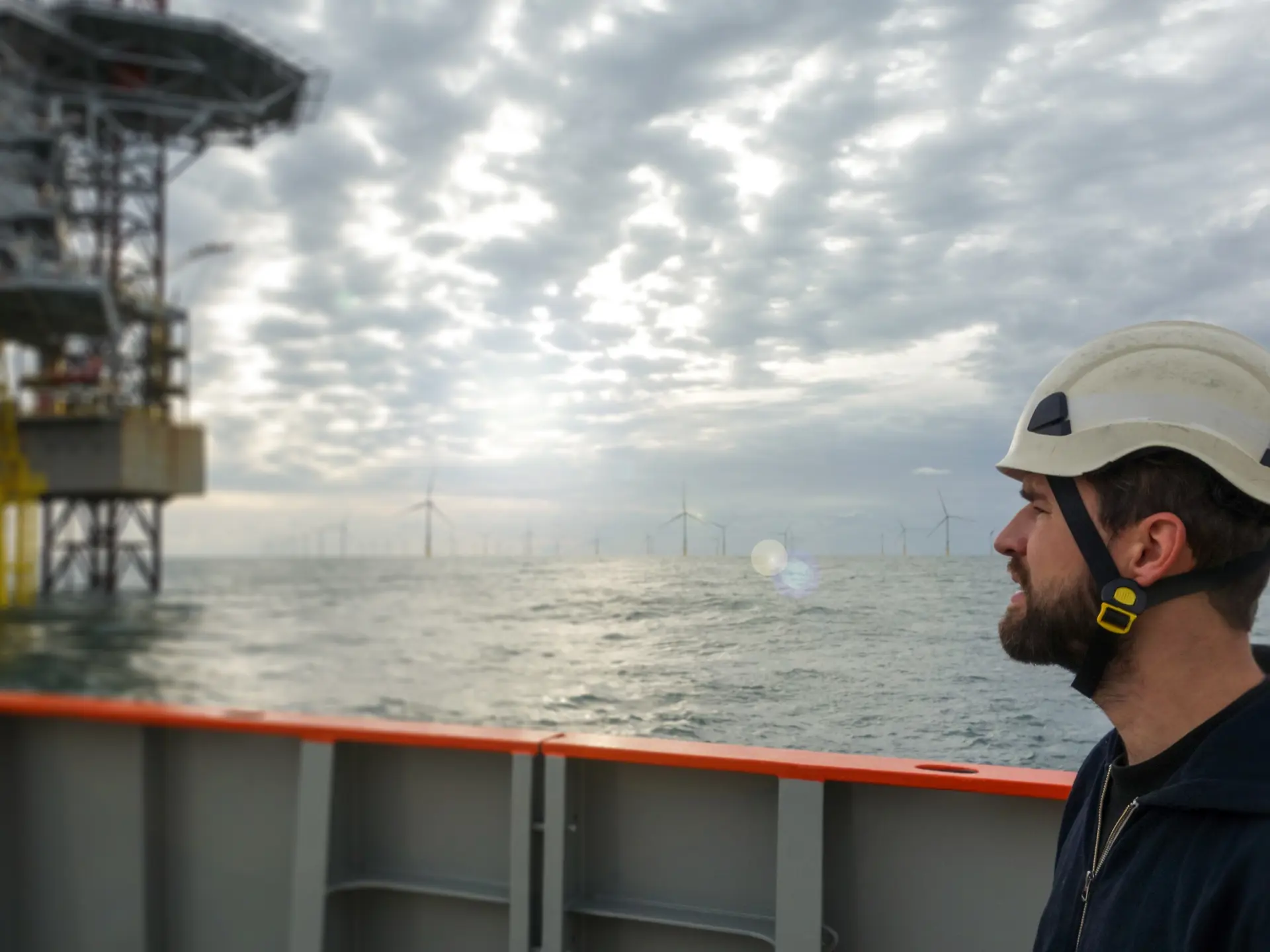 Worker beside offshore wind mill farm