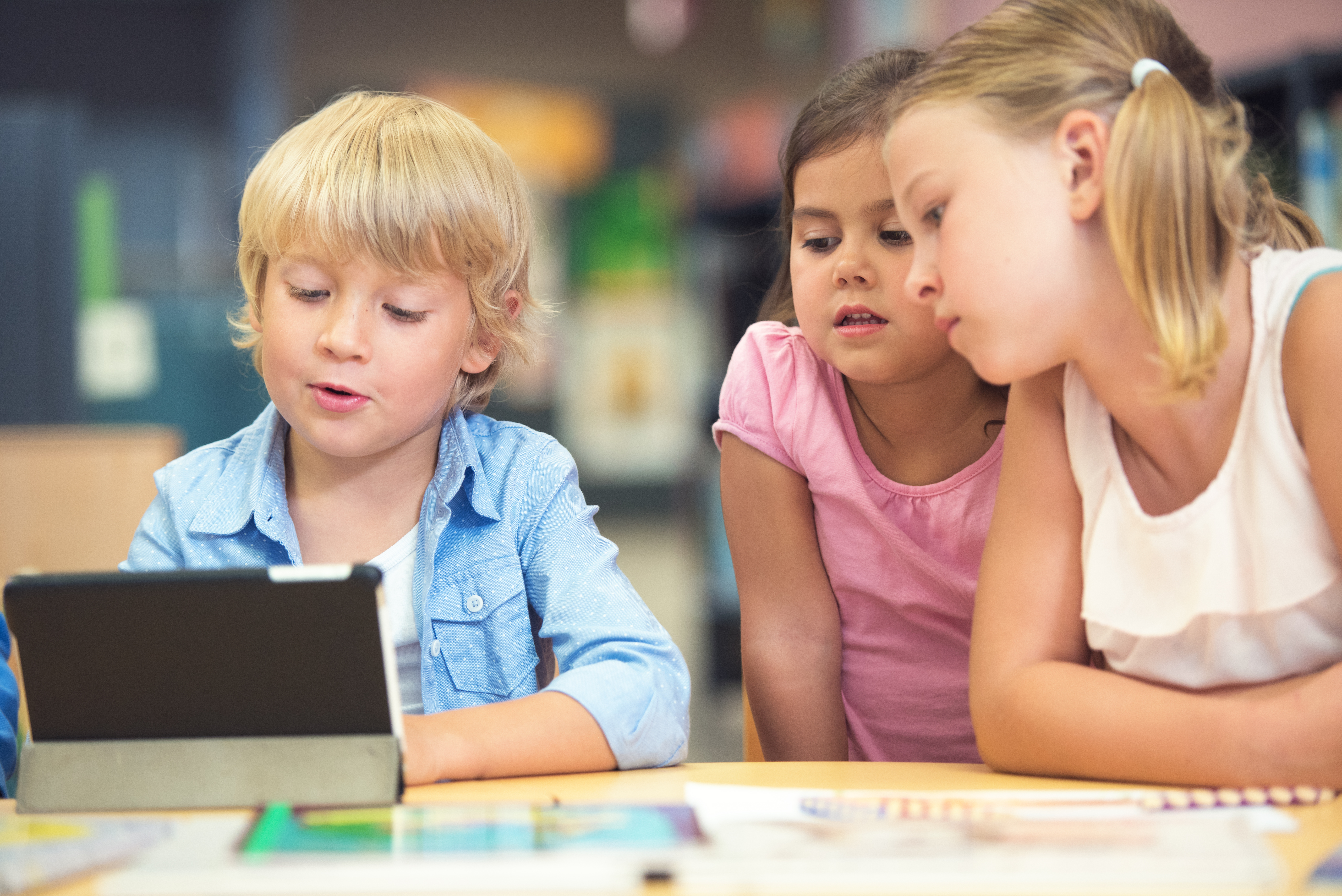 Tre barn i bibliotek med Ipad