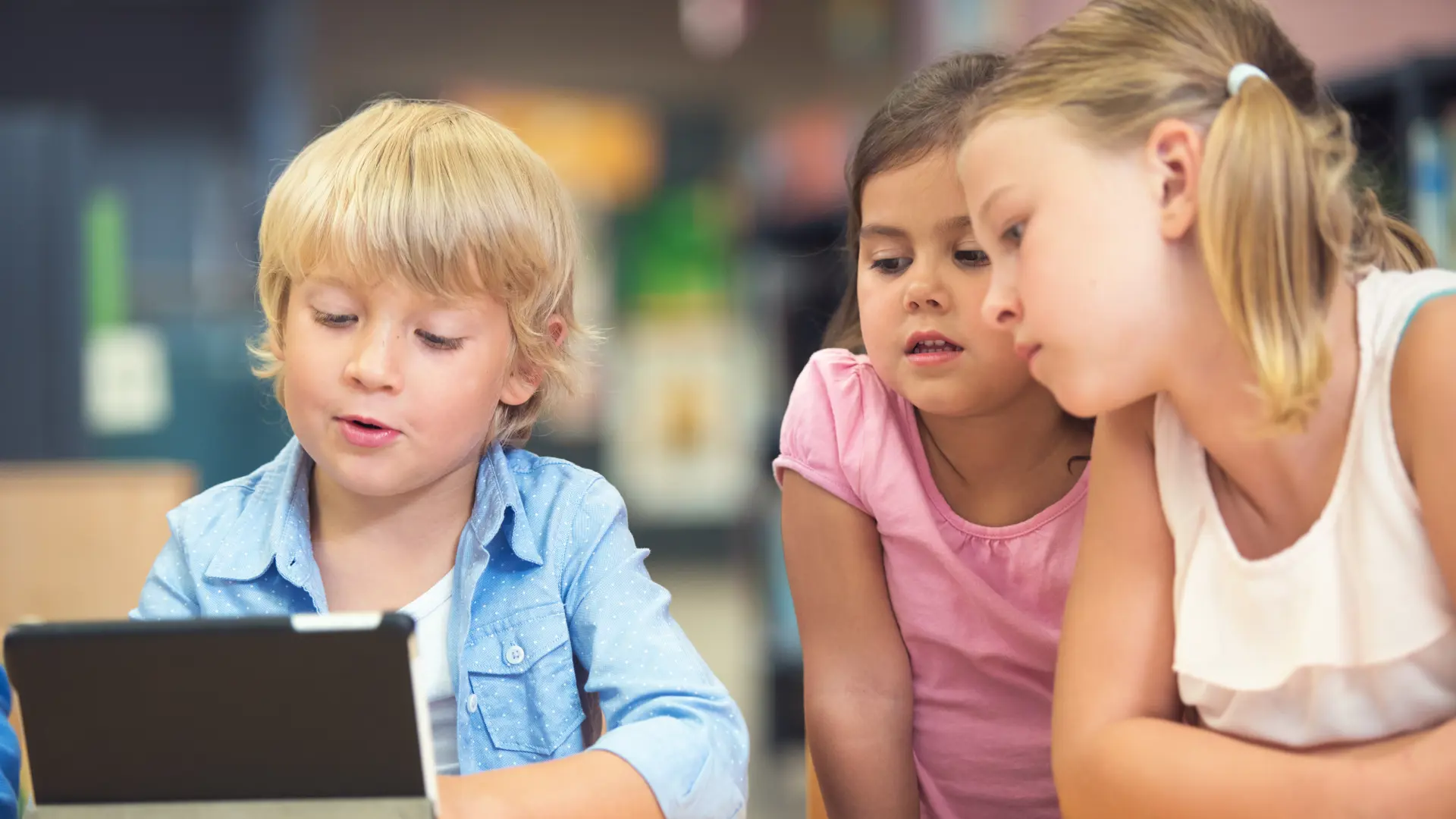 Tre barn i bibliotek med Ipad