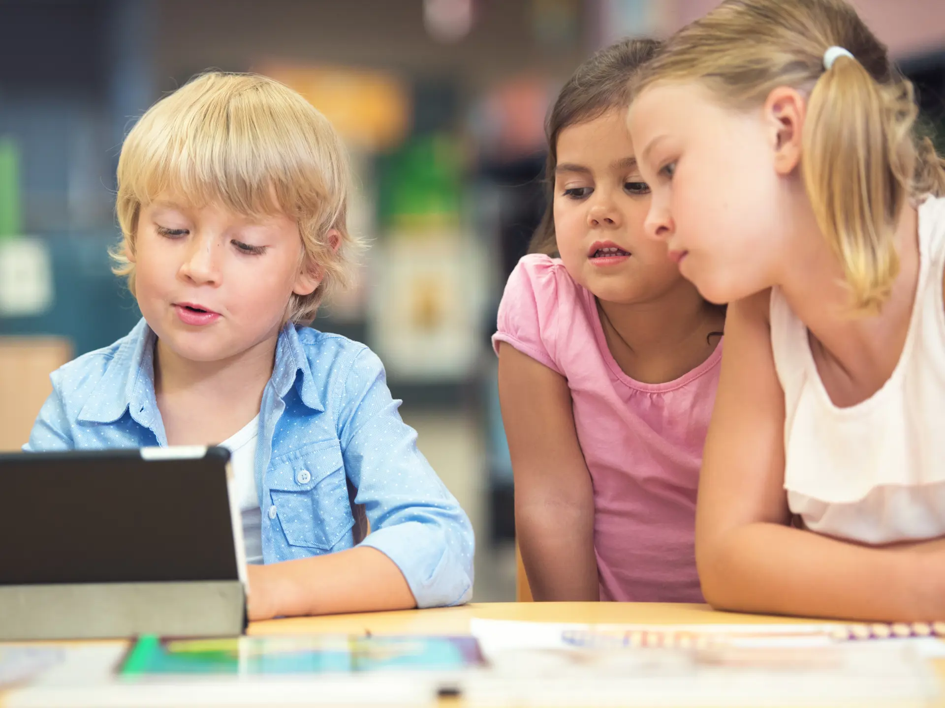 Tre barn i bibliotek med Ipad