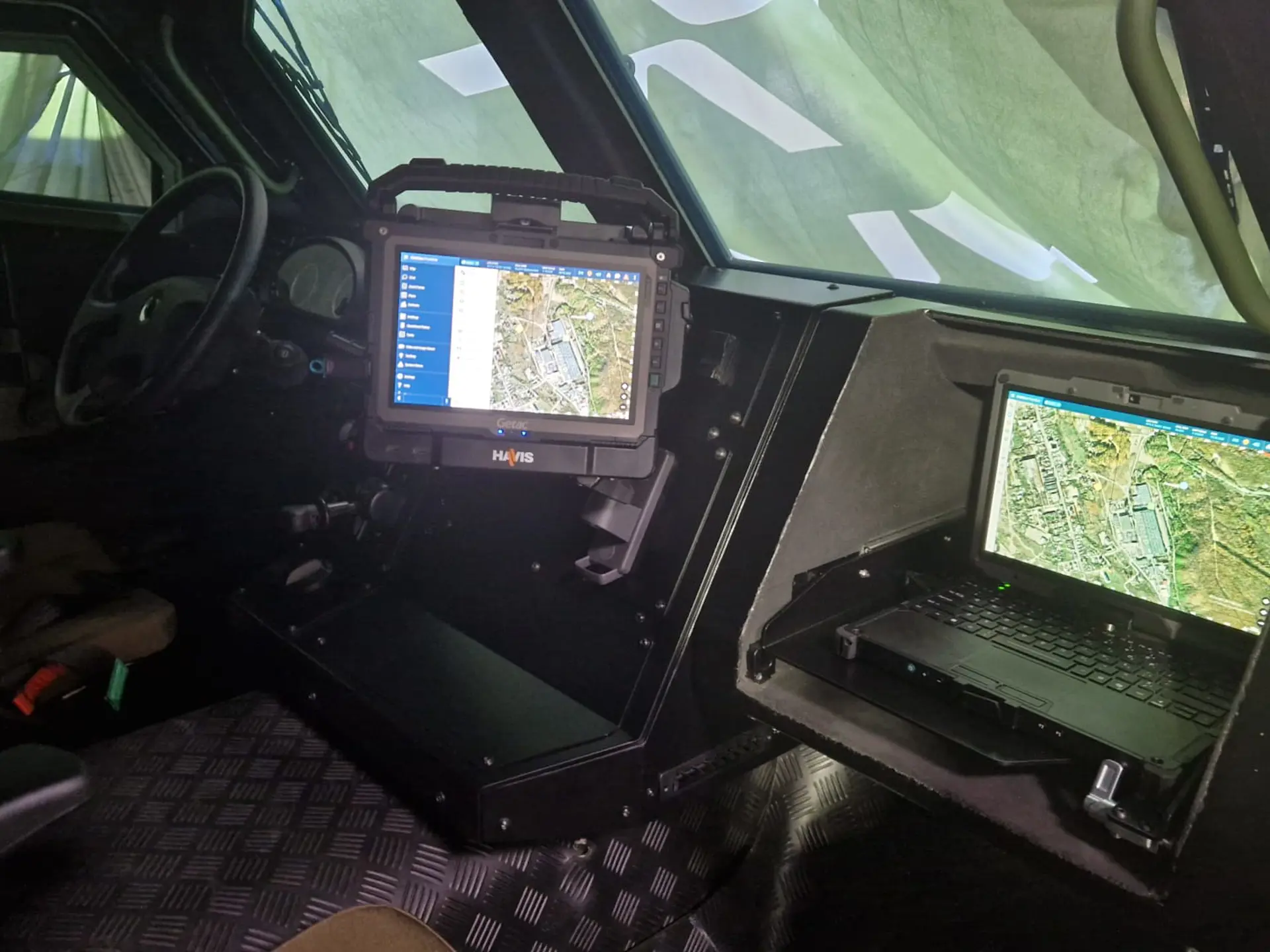 Interior of the VLAH armored vehicle showing rugged tablets and a laptop running SitaWare Frontline by Systematic for digital situational awareness and mission management.