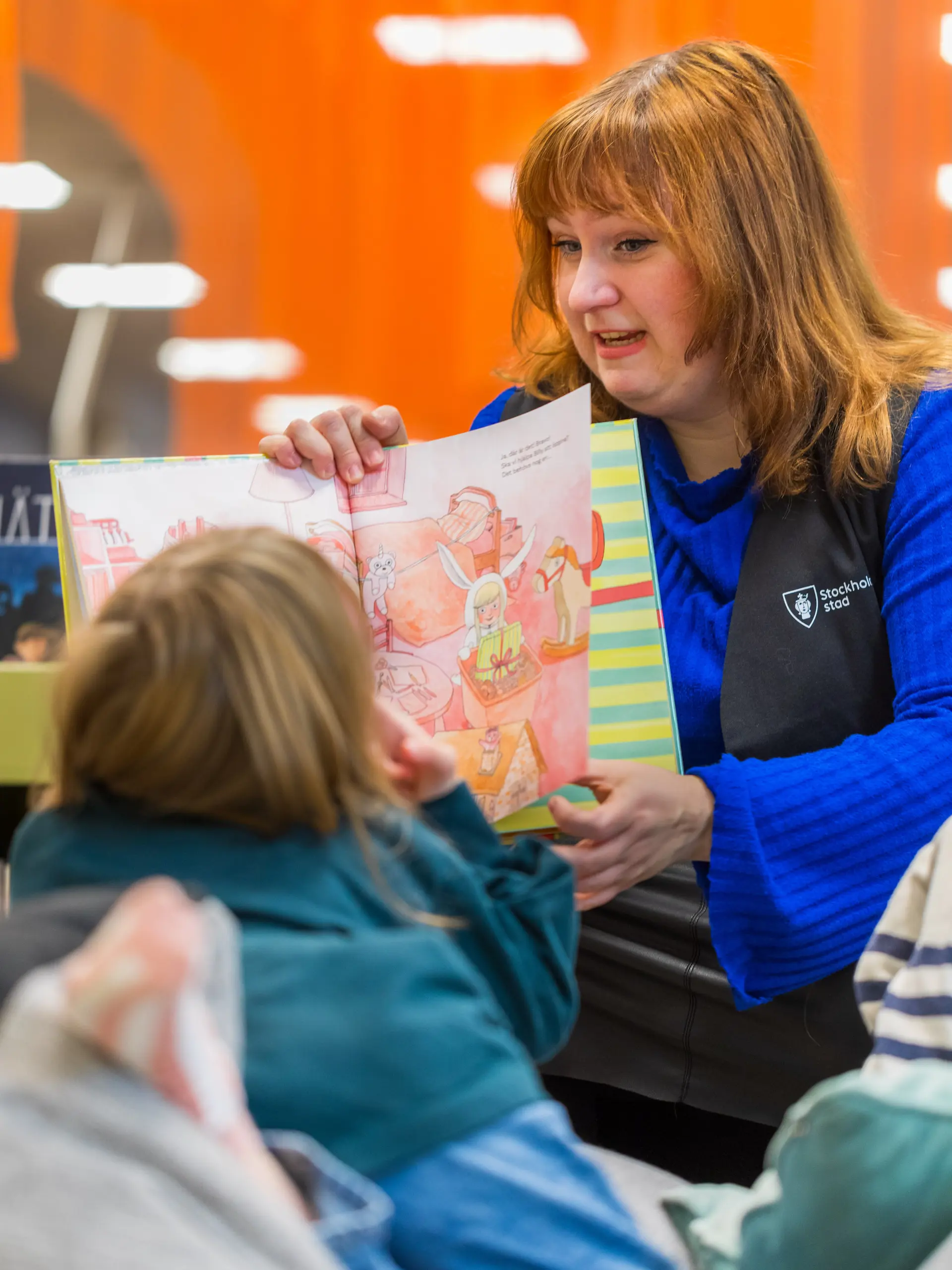 Librarian reads a book to children at Stockholm Public Library
