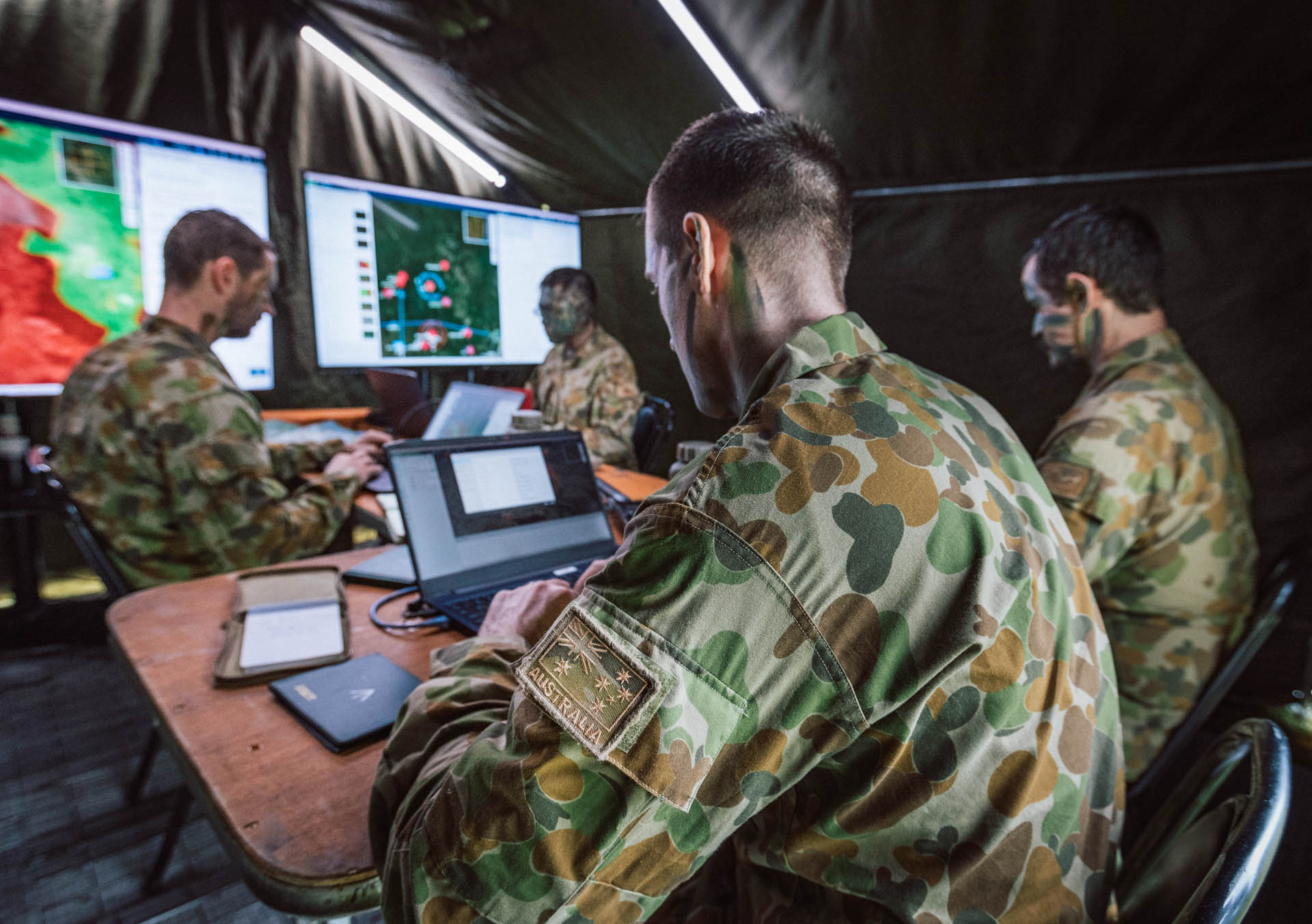 Australian Army personnel working at computer workstations running SitaWare HQ during a military operations exercise.