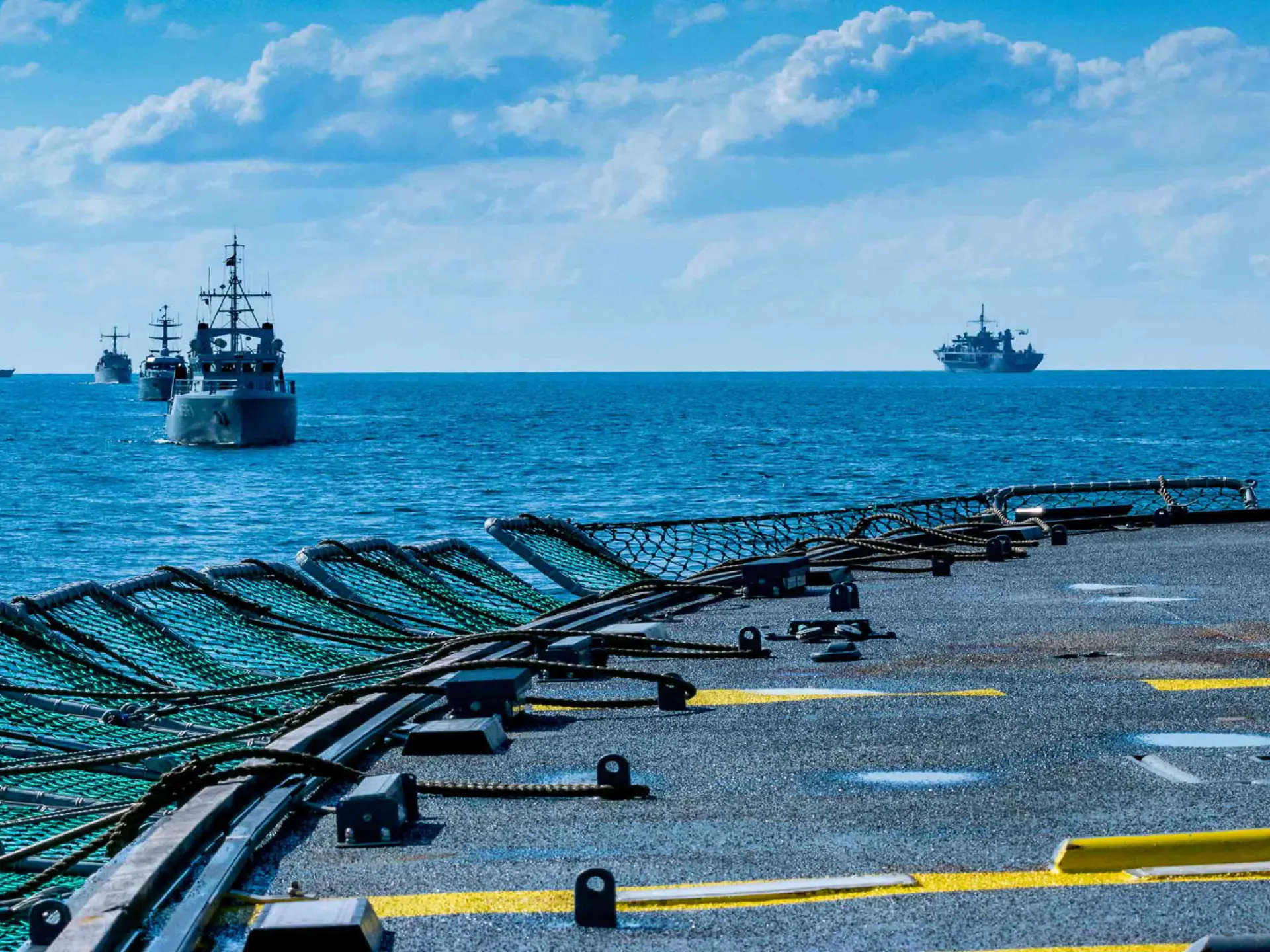 Navy ships next to aircraft carrier