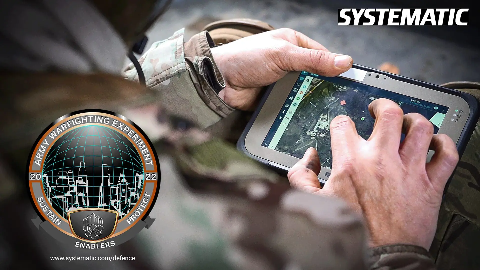 Soldier using a touchscreen device with a digital map during the Army Warfighting Experiment, featuring Systematic branding.
