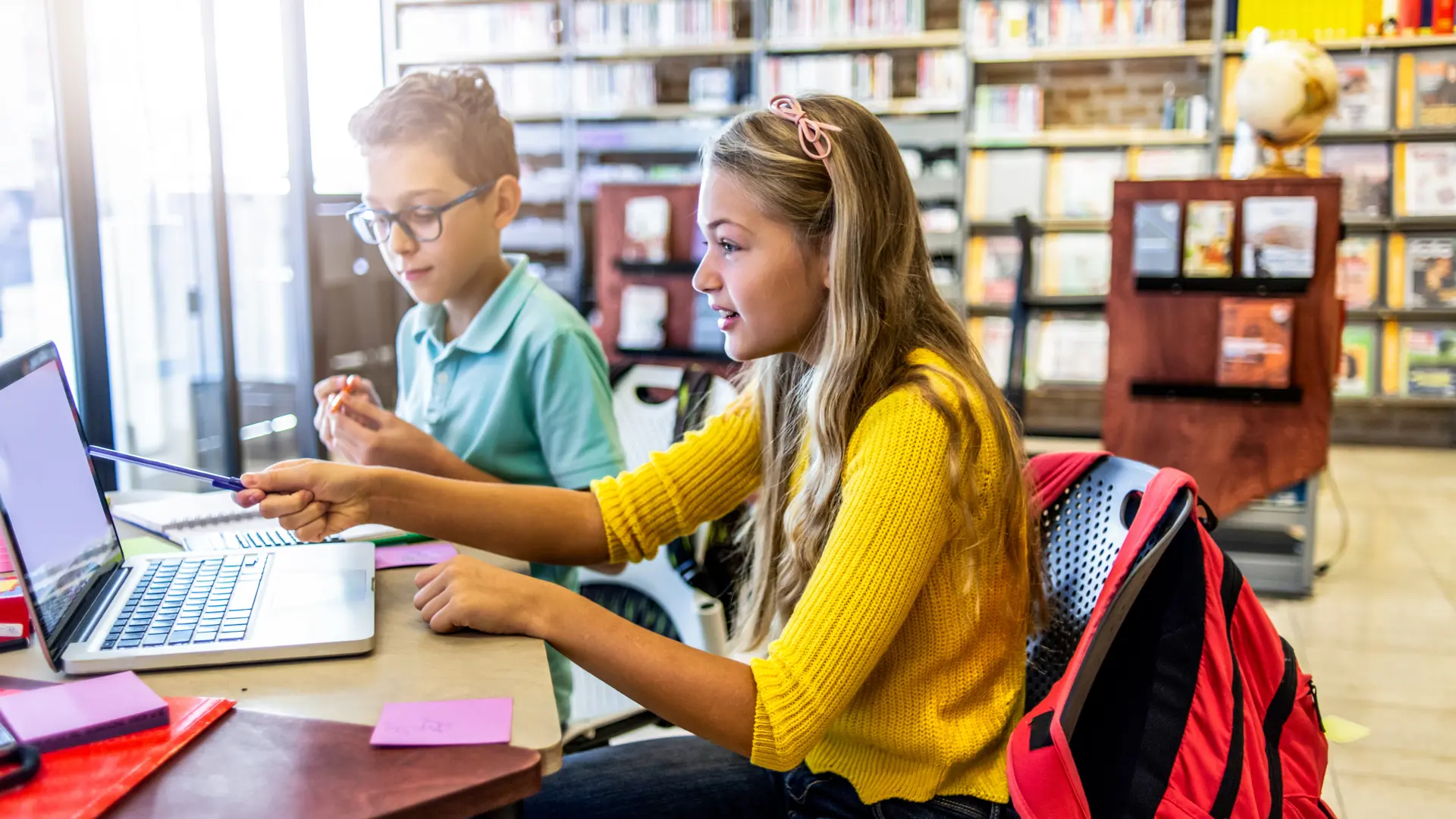 Pojke och flicka arbetar i bibliotek