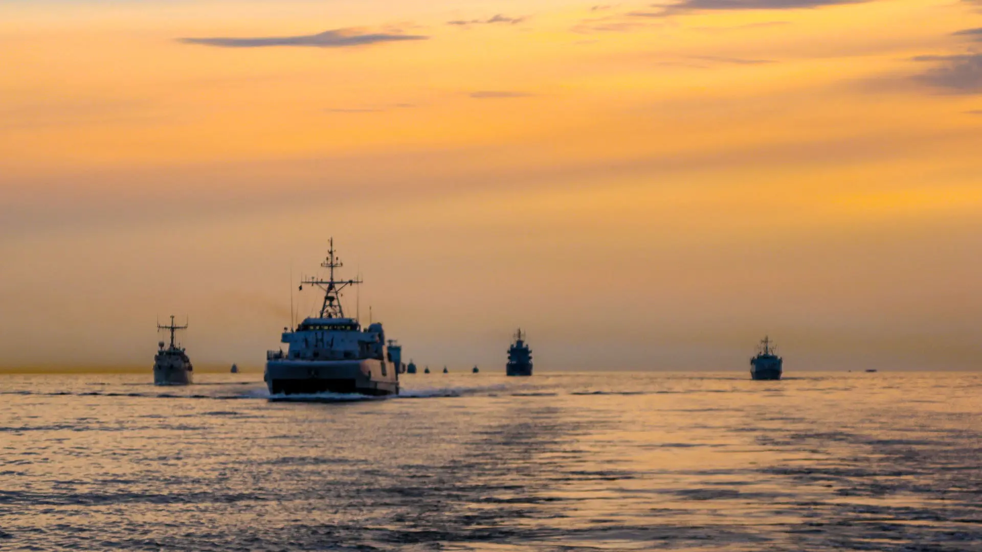 Vessels in formation at sunset performing NATO exercise