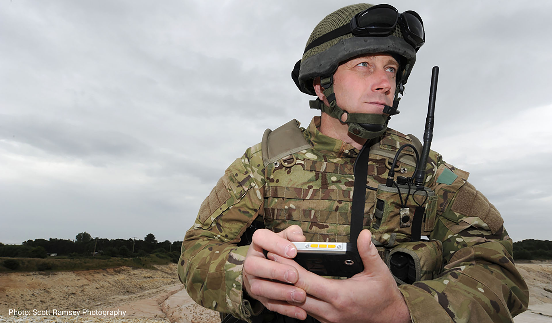 Soldier on the lookout with mobile device and HF radio