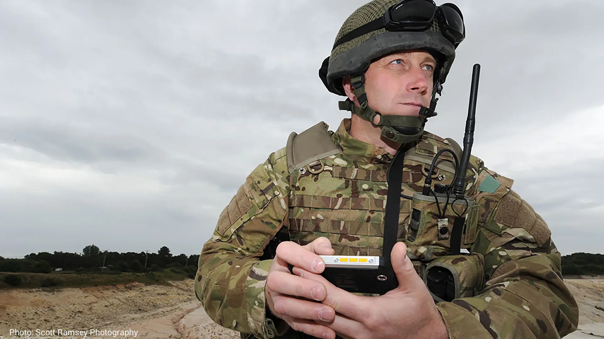 Soldier on the lookout with mobile device and HF radio