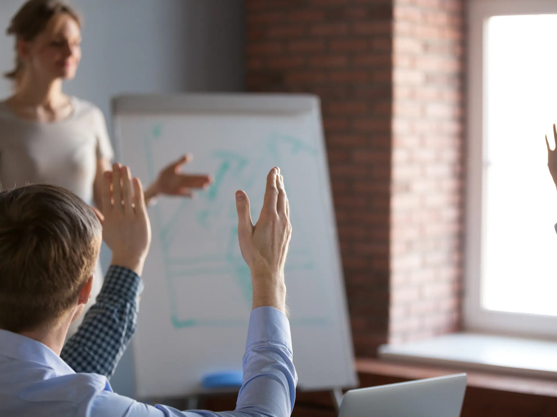A couple of raised hands in a classroom