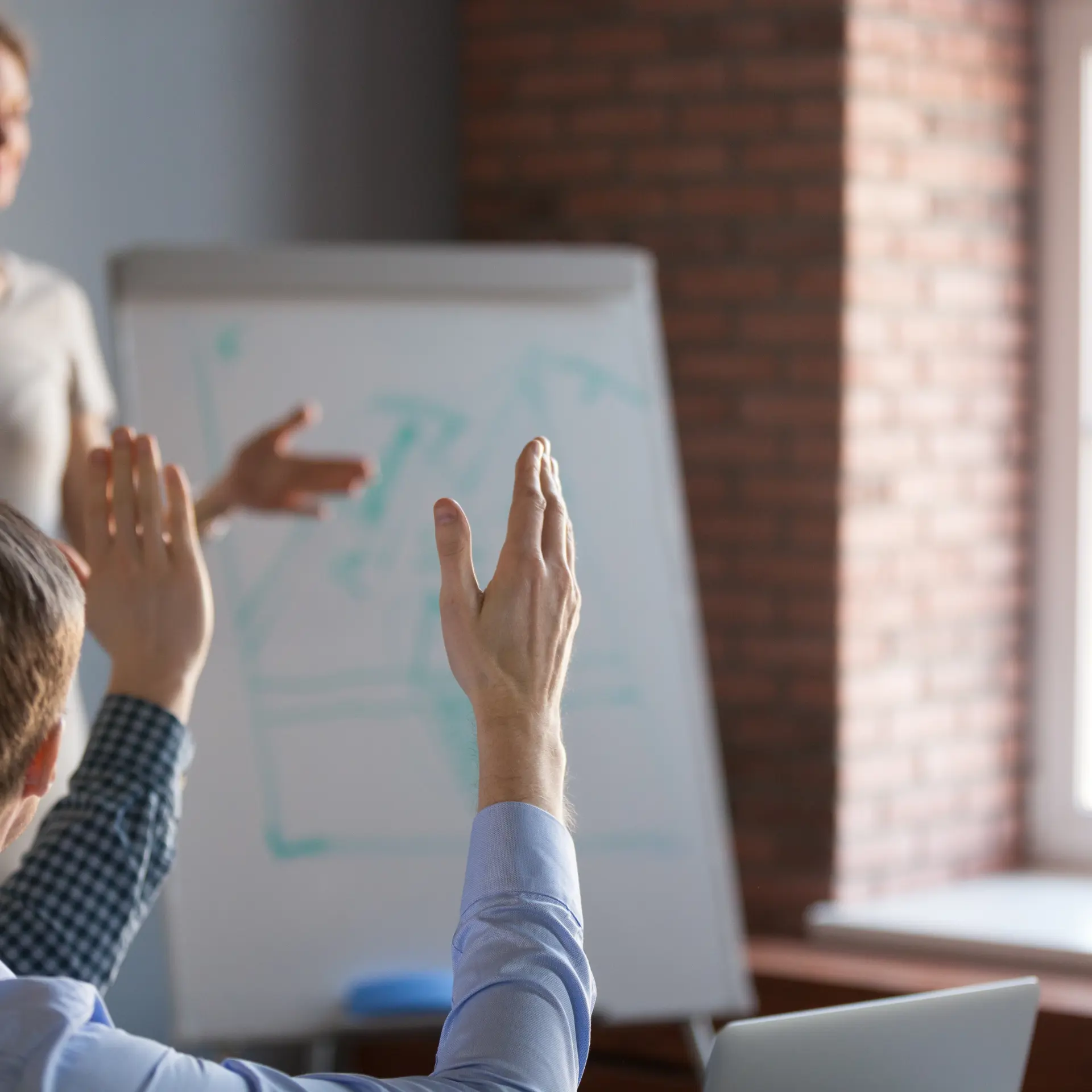 A couple of raised hands in a classroom