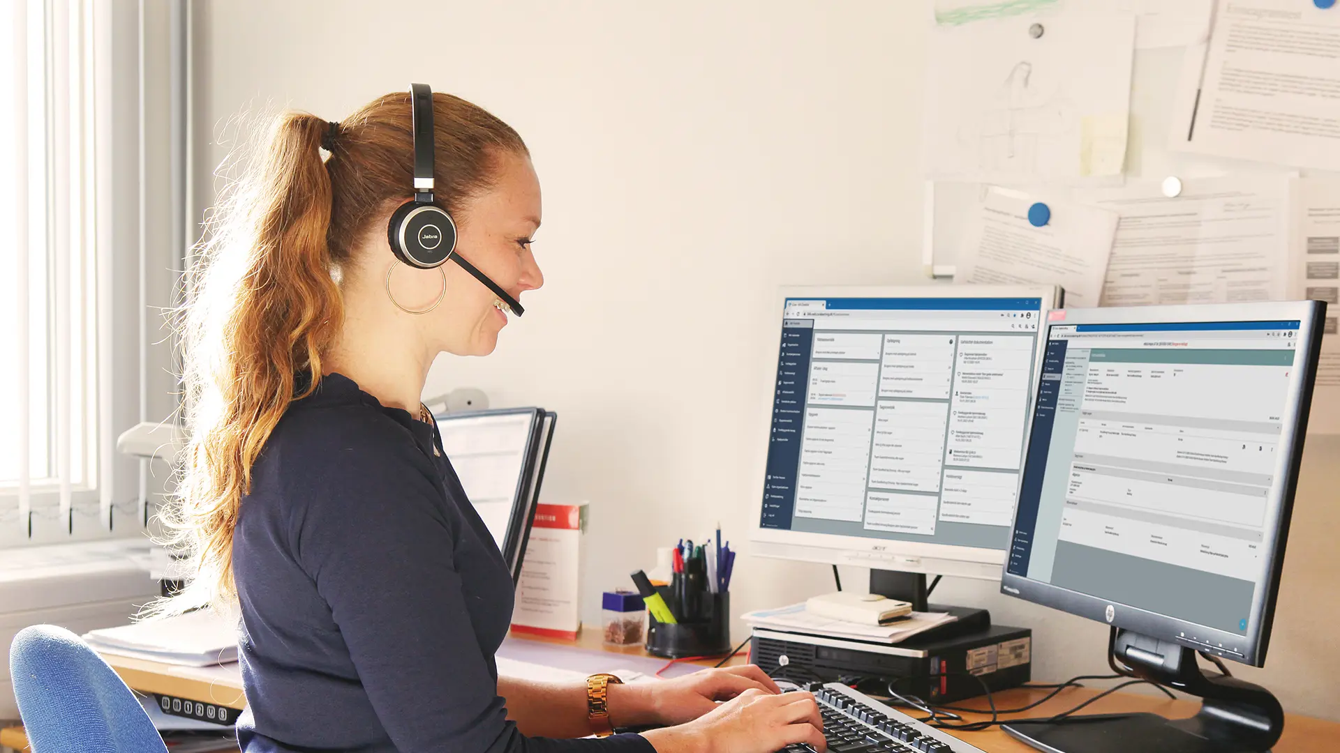 Socialrådgiver snakker i telefon med computer med Columna Cura Social