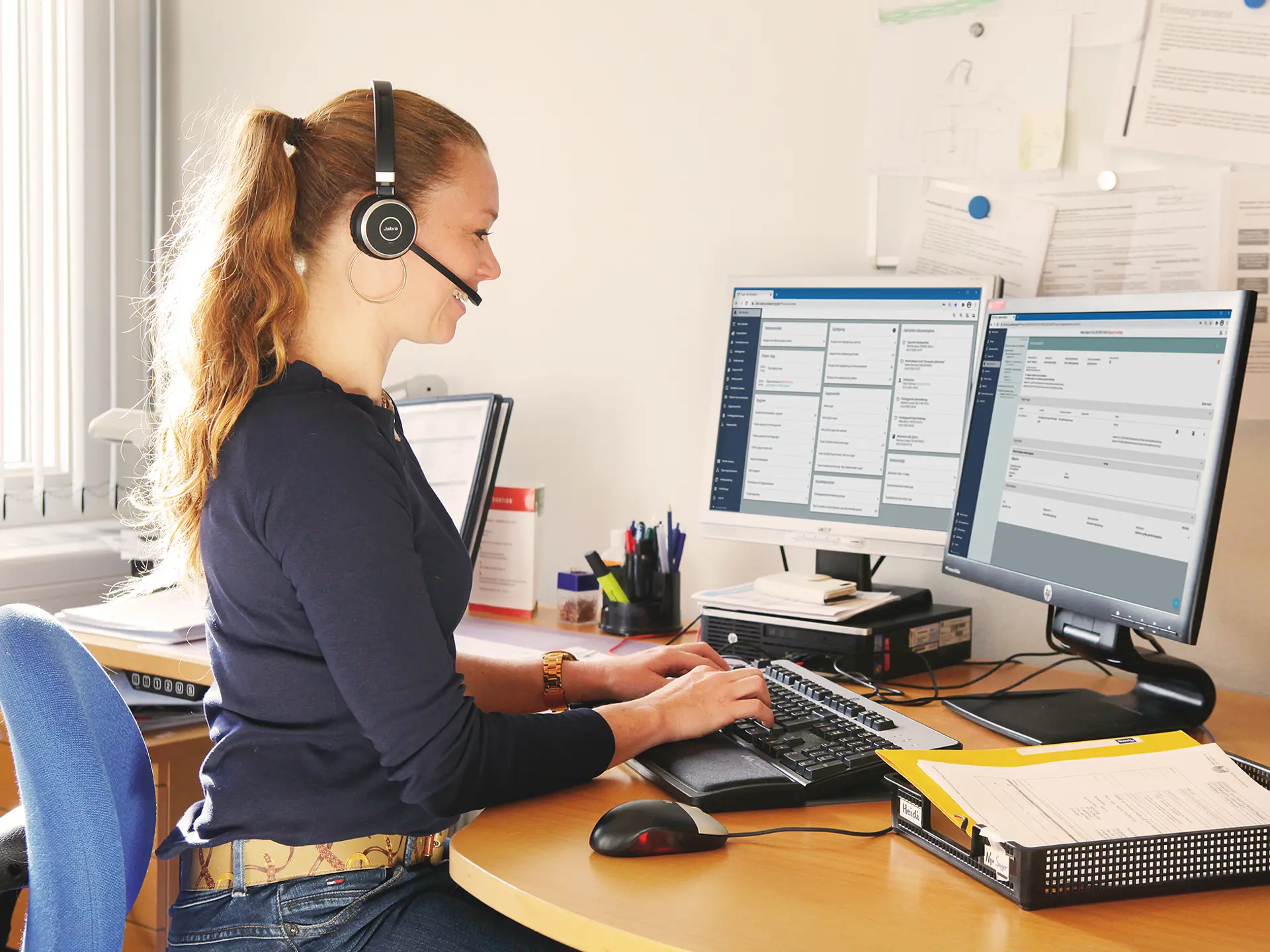 Socialrådgiver snakker i telefon med computer med Columna Cura Social