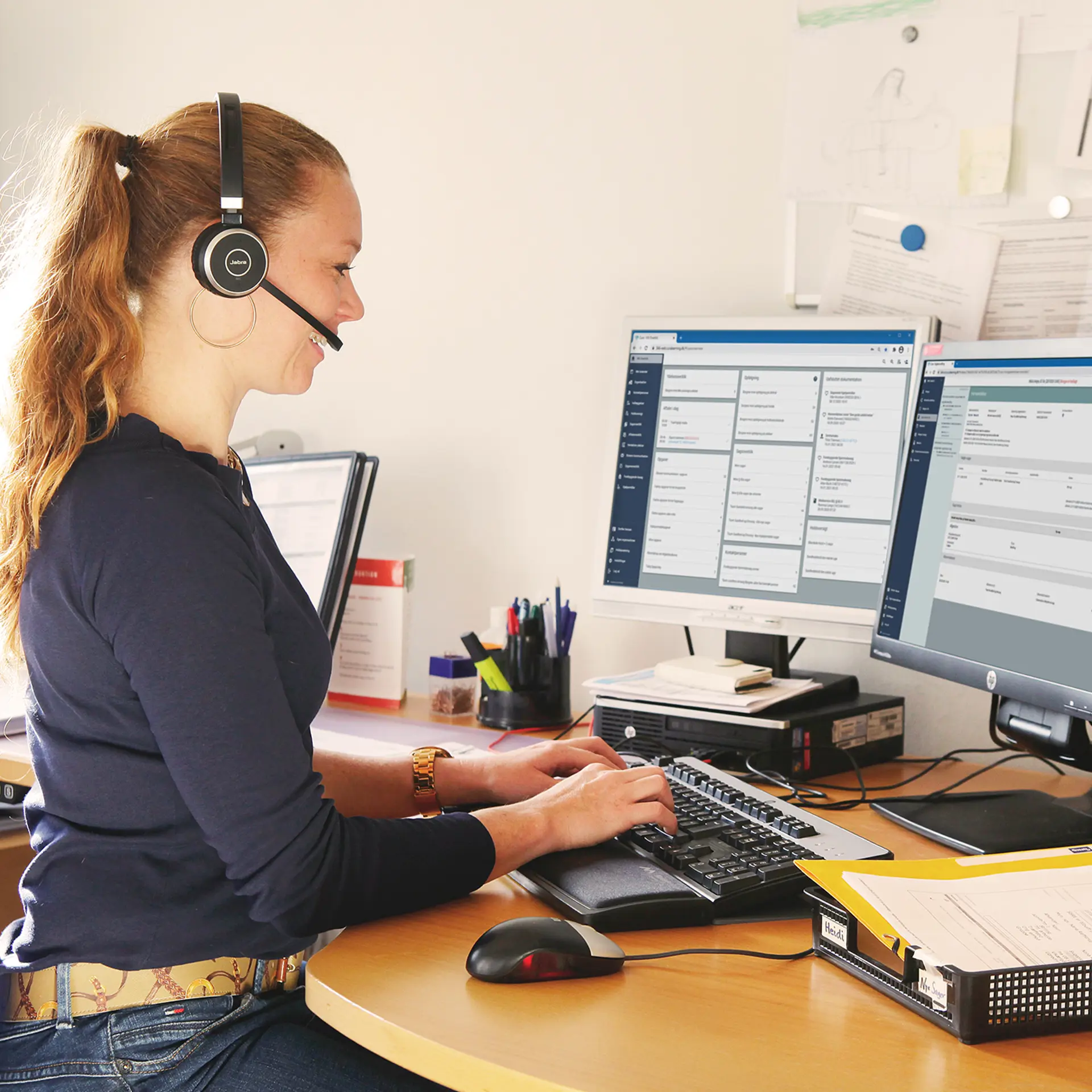Socialrådgiver snakker i telefon med computer med Columna Cura Social