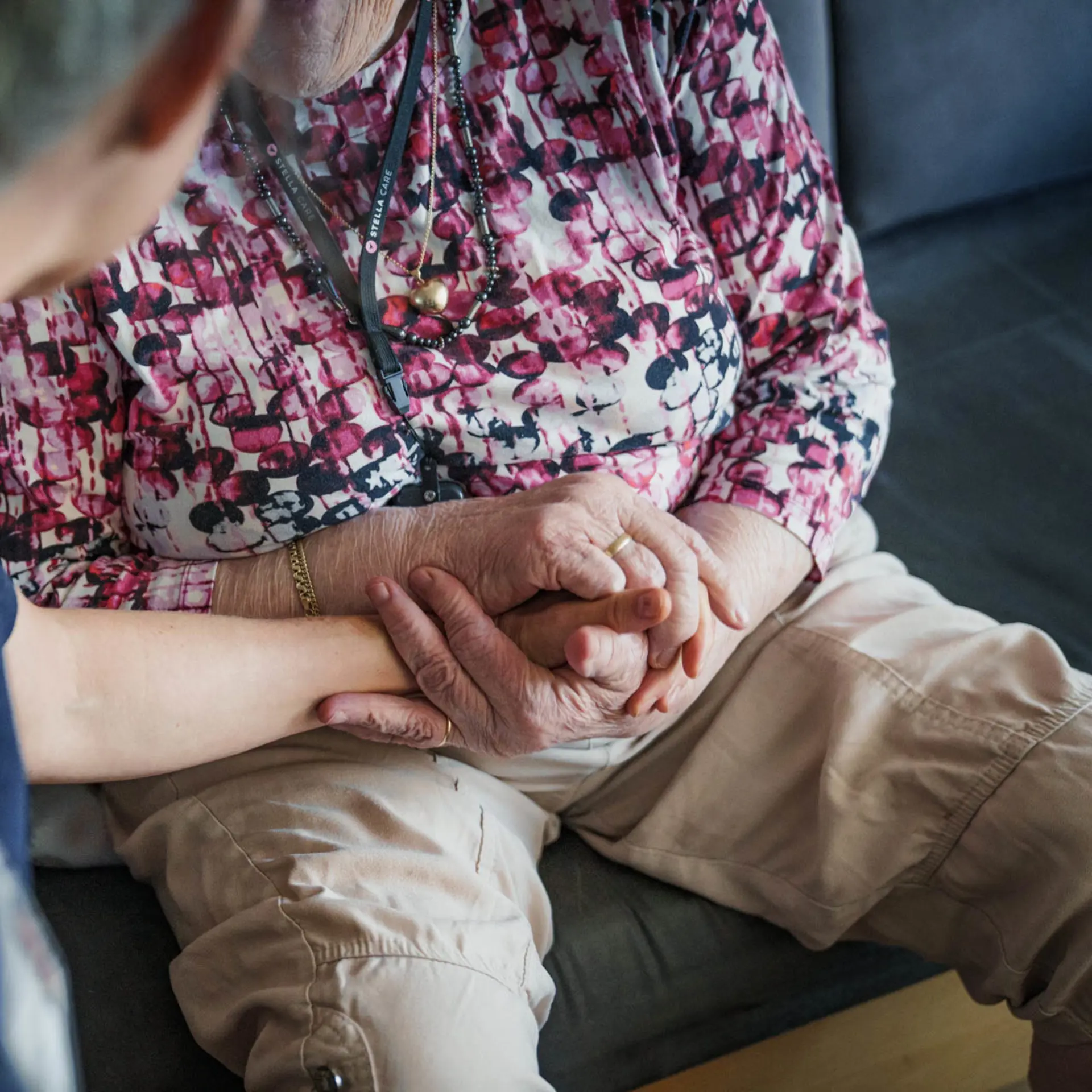 Social and healthcare assistant holding a citizen’s hand in a supportive and compassionate gesture.