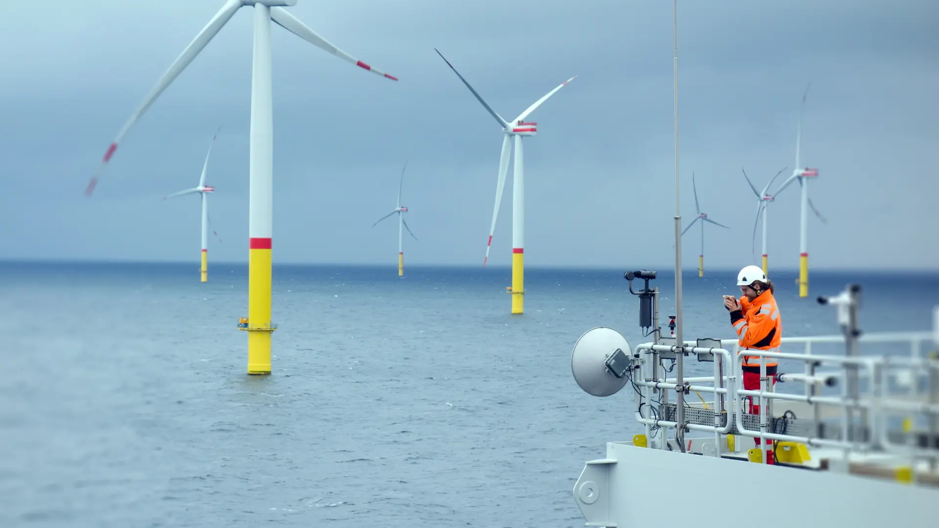 Operator on a ship next to a few wind turbines