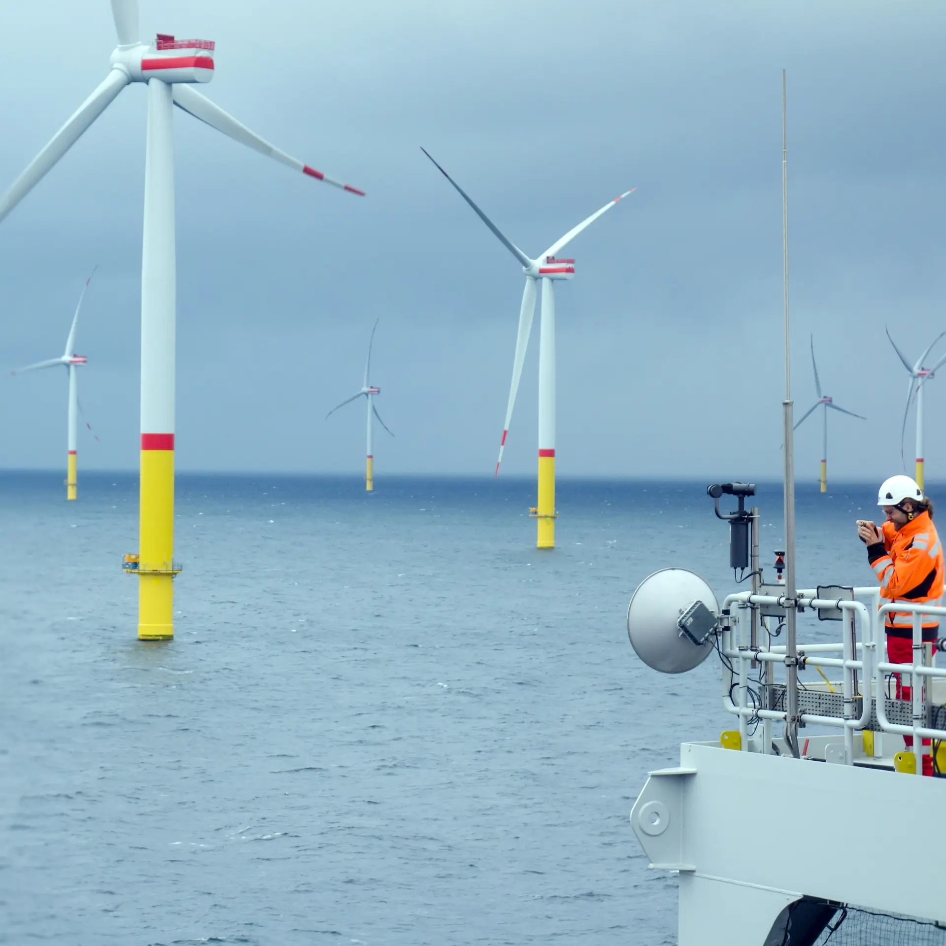 Operator on a ship next to a few wind turbines