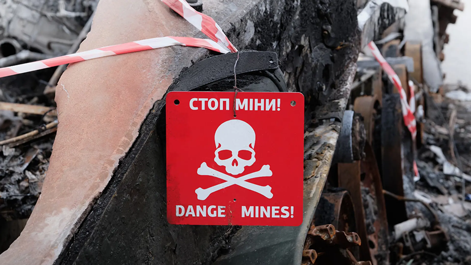 Landmine warning sign featuring a danger symbol warning about explosive hazards nearby.