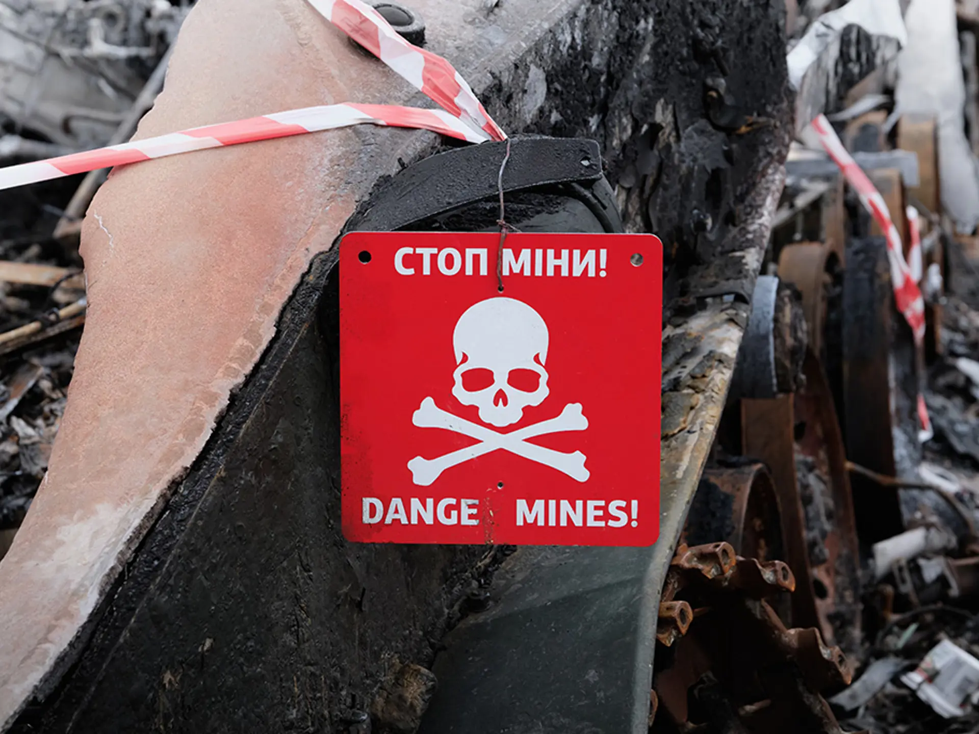 Landmine warning sign featuring a danger symbol warning about explosive hazards nearby.