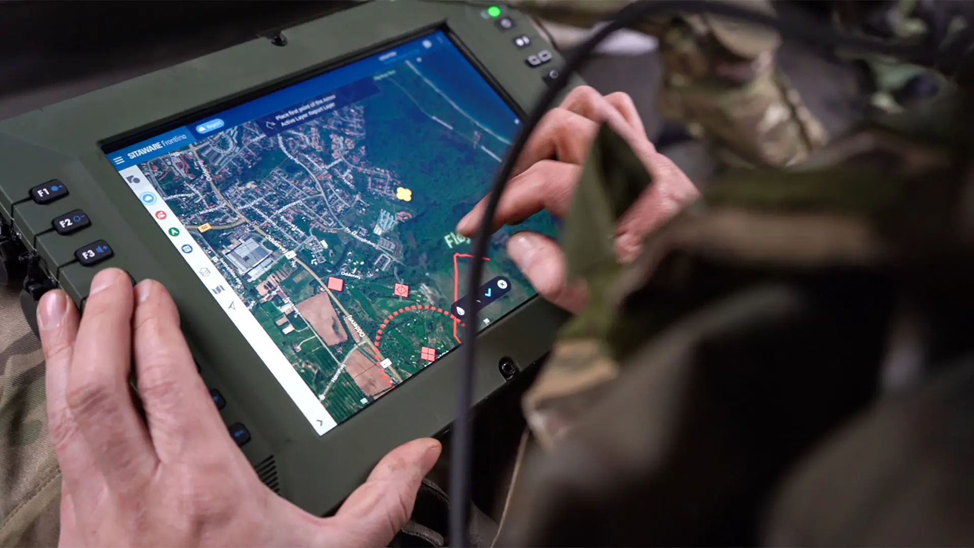 A soldier operates SitaWare Frontline inside an armoured military vehicle.